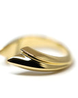 Angled shot of Tidal Ring in Yellow Gold – A striking unisex gold ring featuring a smooth, sculptural silhouette.
