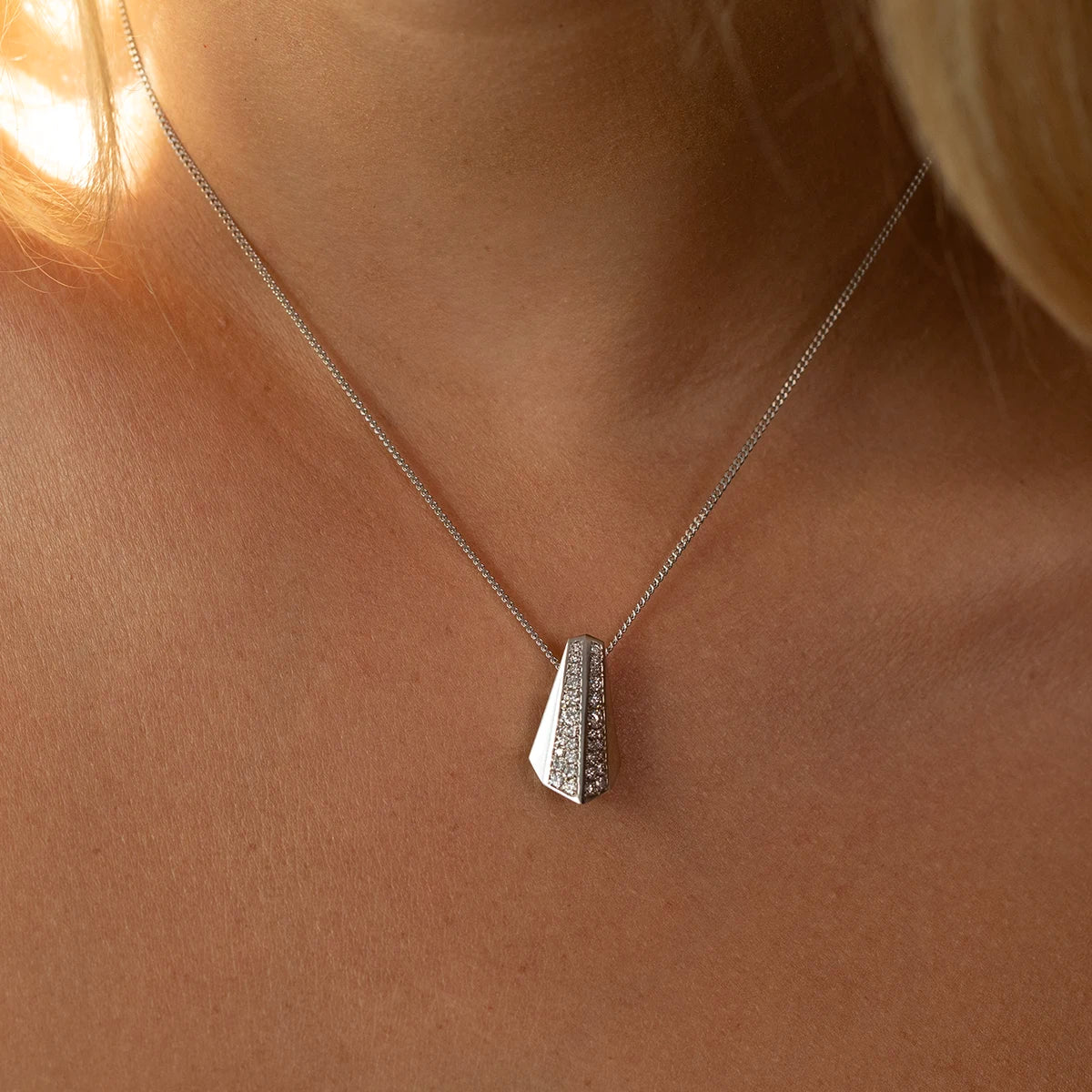 Close-up of the Balast pendant in 14k white gold, featuring a sleek geometric silhouette and pavé-set diamonds. A modern statement necklace handcrafted by Bena Jewelry in Montreal.