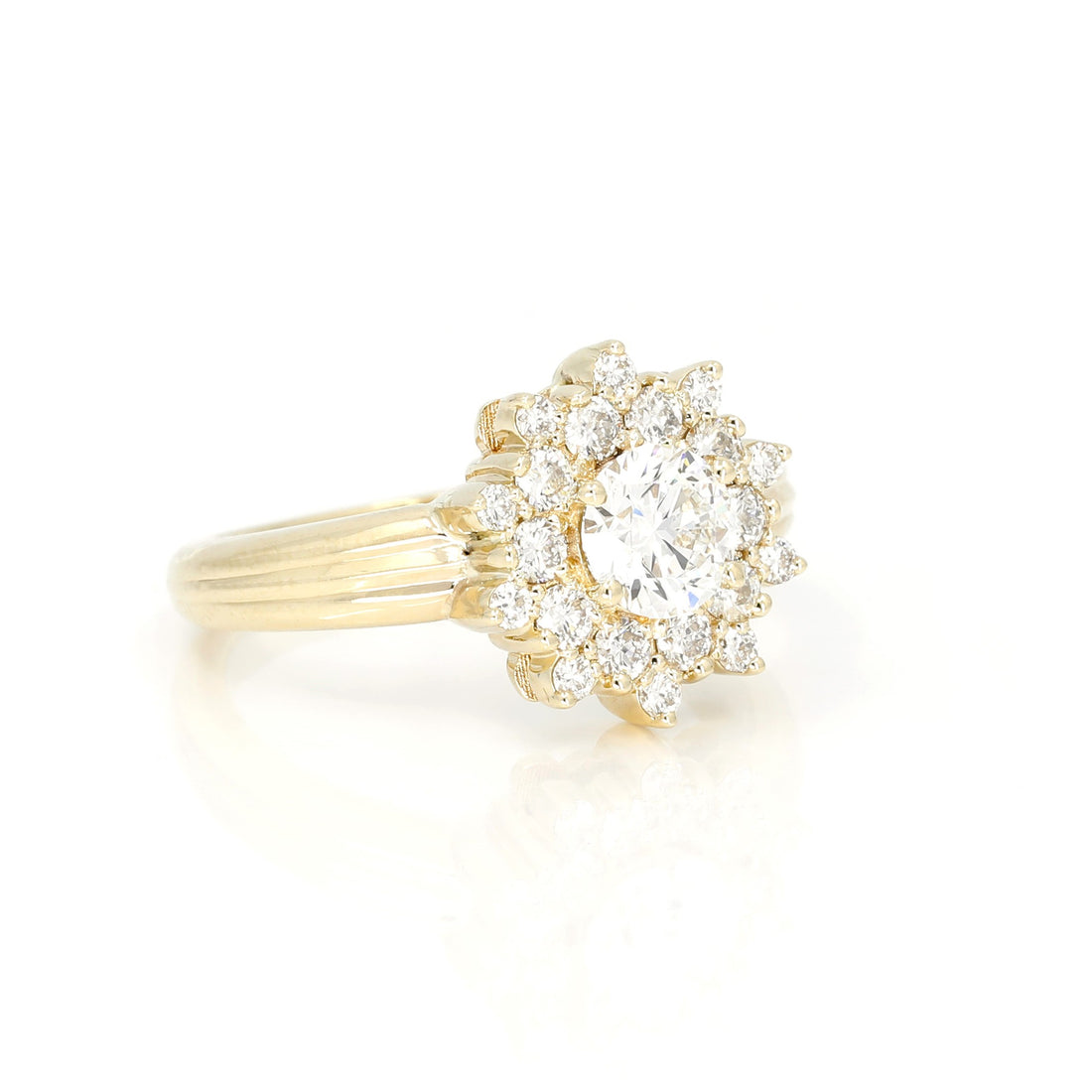 side view of lab grown diamond halo and central round shape gemstone yellow gold designer bridal ring made in montreal by bena jewelry on white background