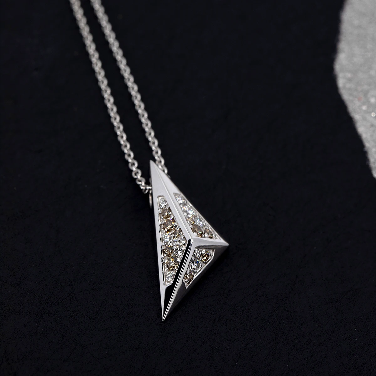 Modern pyramidal pendant in white gold with lab-grown diamonds, set against a dark background. Unique designer jewelry by Bena Jewelry, handmade in Montreal.