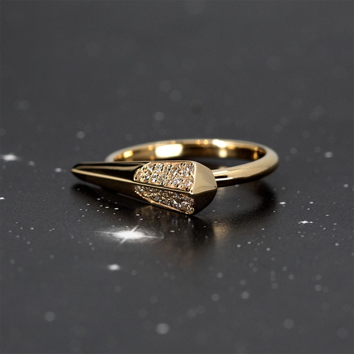 This edgy yellow gold ring with diamonds and geometric shape is made in Montreal by independent jewelry designer Bena Jewelry. This contemporary piece of jewelry is seen photographed on a photo of a starry sky.