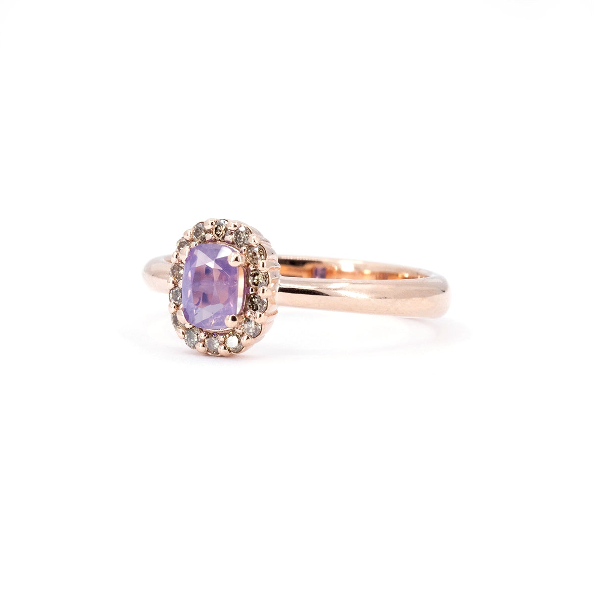 Three-quarter view of a rose gold sapphire ring by Bena Jewelry featuring an opalescent purple sapphire surrounded by champagne diamonds. Handmade designer jewelry from Montreal.