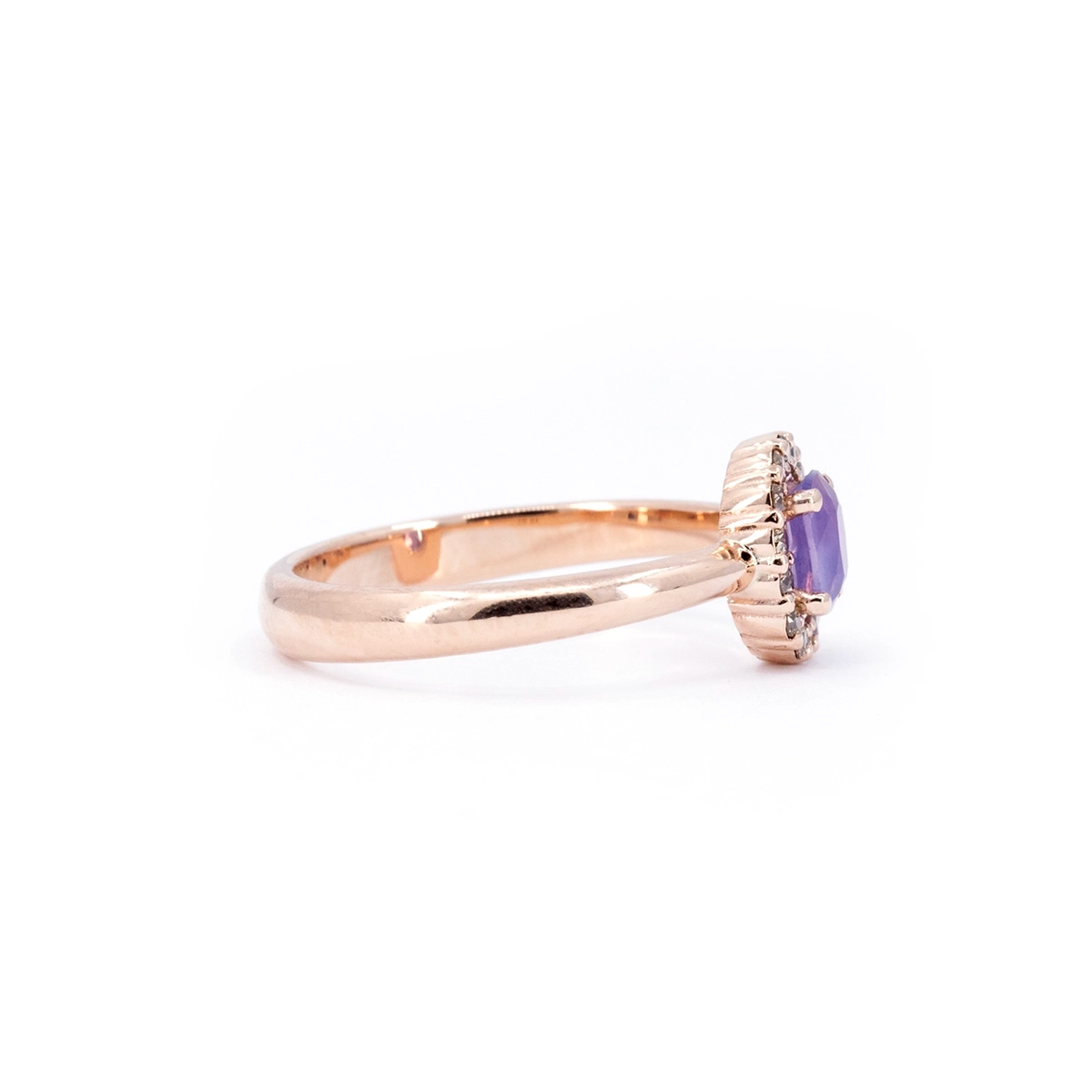 Side profile of a Bena Jewelry rose gold ring with an oval purple sapphire and champagne diamond halo. Modern fine jewelry designed in Montreal, Canada.