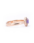 Side profile of a Bena Jewelry rose gold ring with an oval purple sapphire and champagne diamond halo. Modern fine jewelry designed in Montreal, Canada.