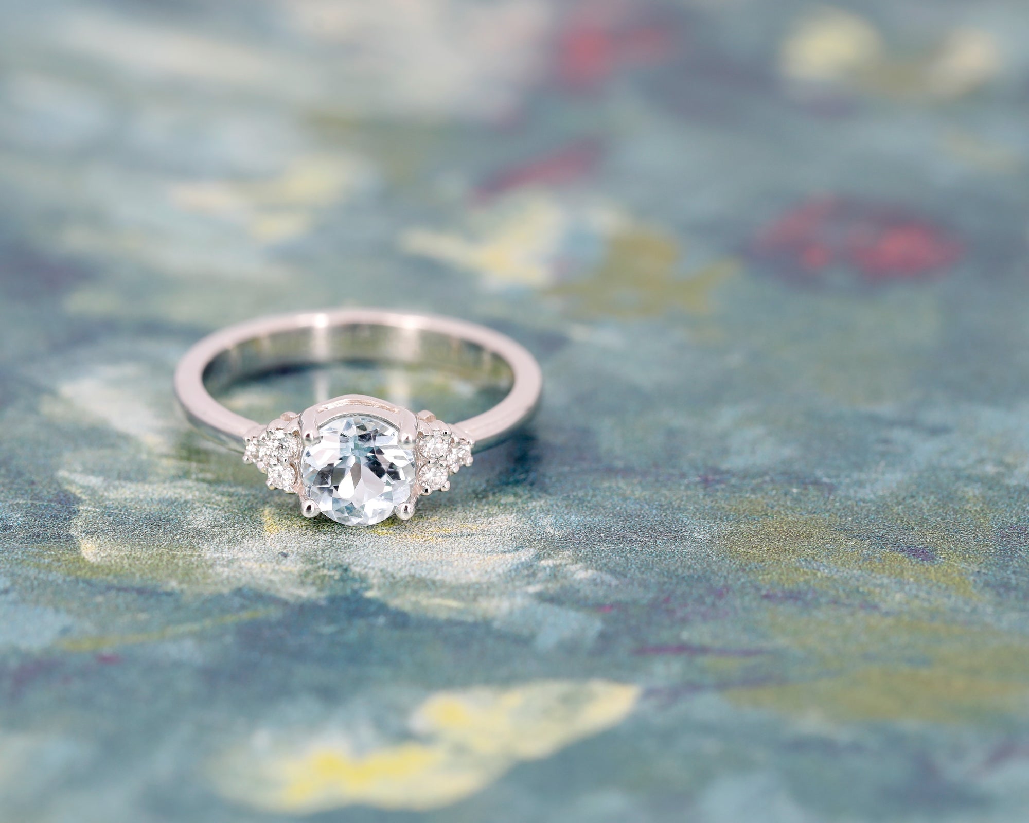 Top view: Focus on the aquamarine centerpiece and the arrangement of the diamonds in the white gold setting. Designed by Bena Jewelry, made in Montreal, Canada.