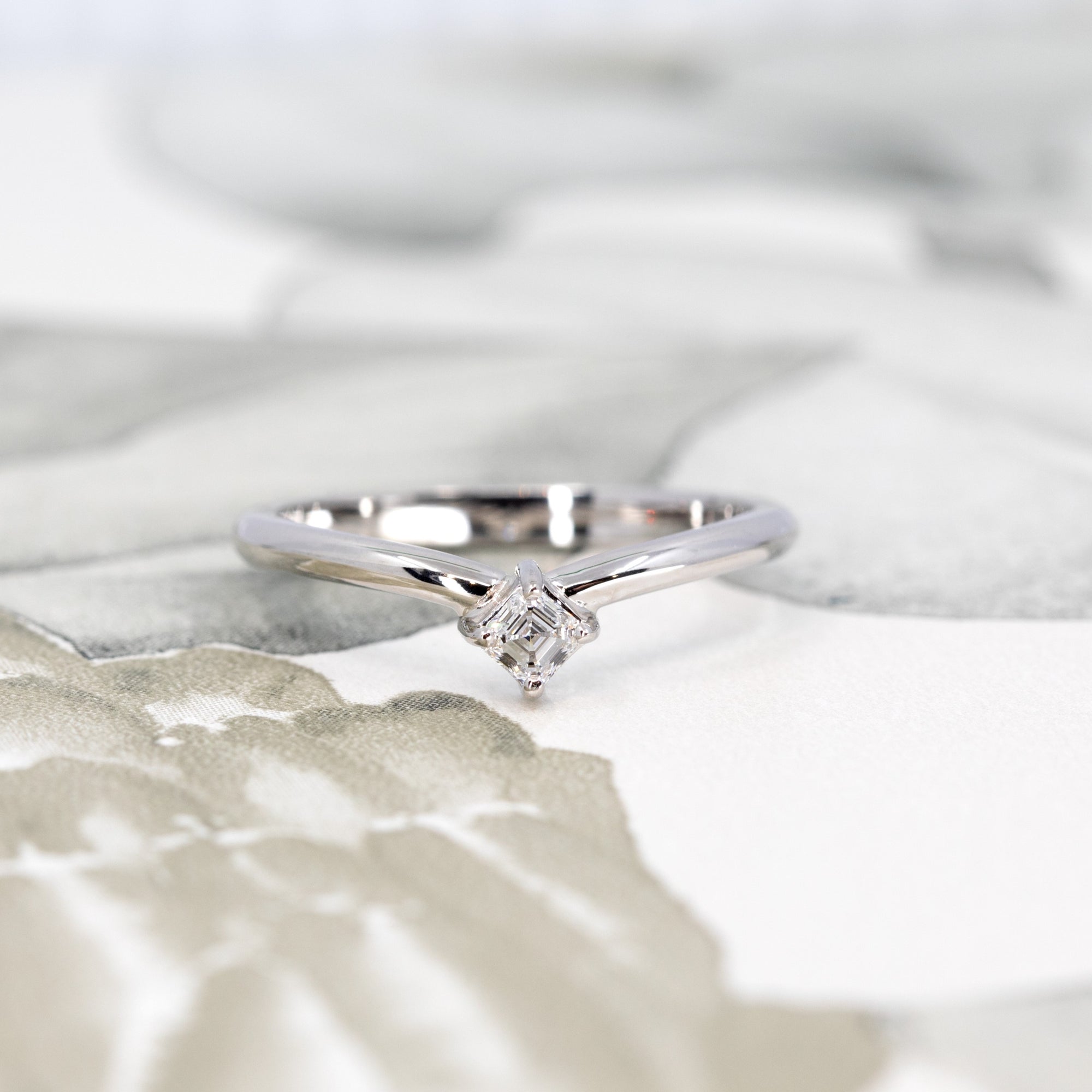 Close-up view of Asscher-cut diamond set in white gold, highlighting the intricate cut and geometric brilliance, crafted by Bena Jewelry designer.