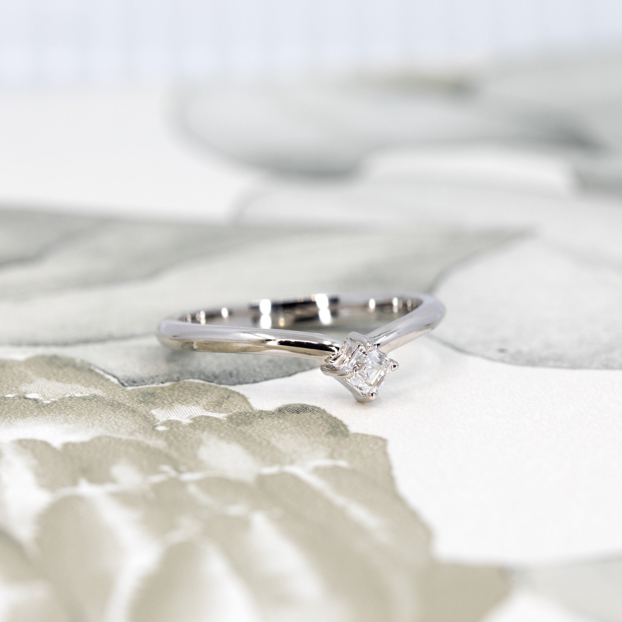 Side view of the edgy white gold ring with Asscher-cut diamond made by Bena Jewelry, showcasing the gentle curve and bold design elements.