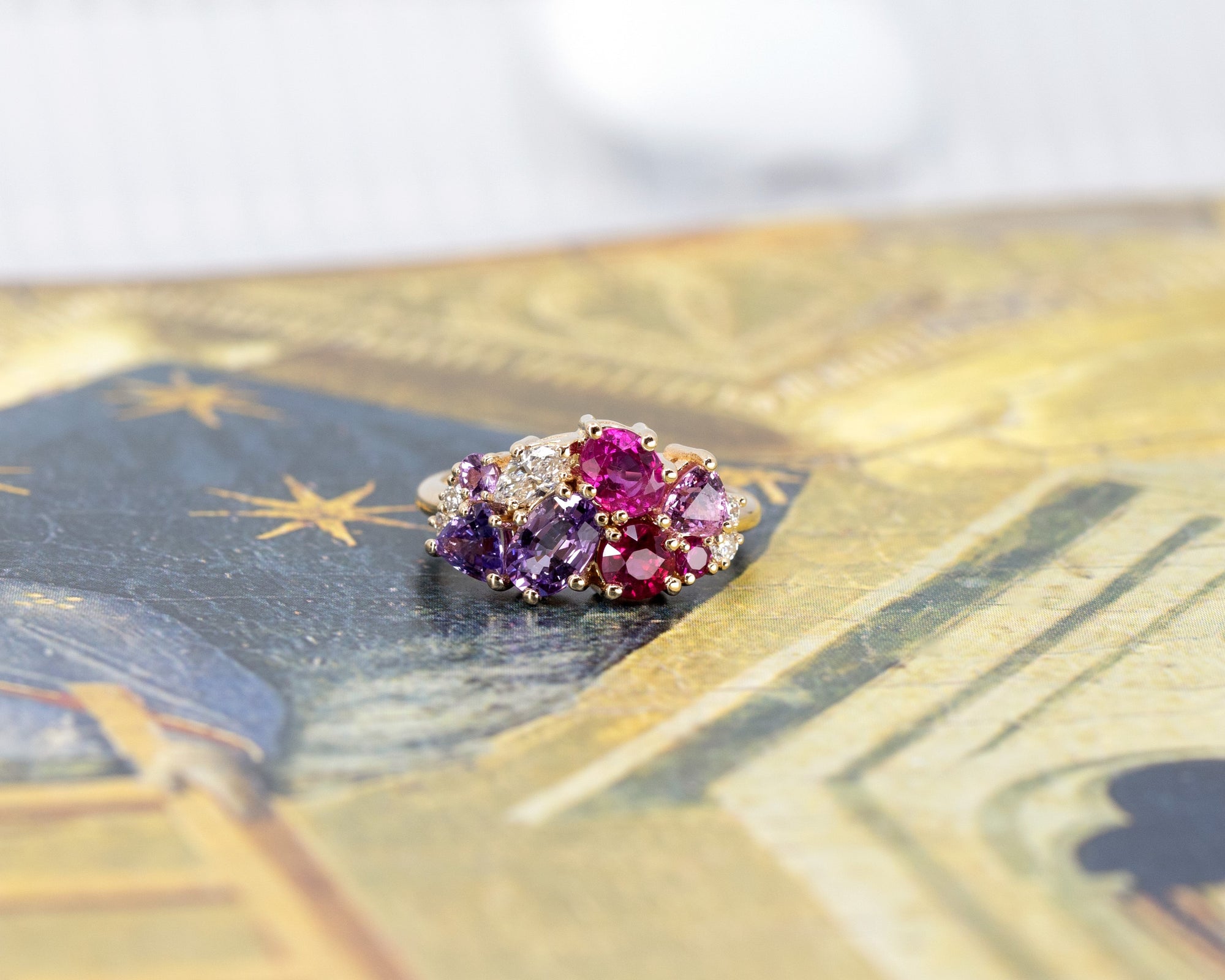 Focuses on the rich hues of the violet sapphire and the vibrant rubies against the yellow gold. Made by Bena Jewelry, Montreal, Canada.