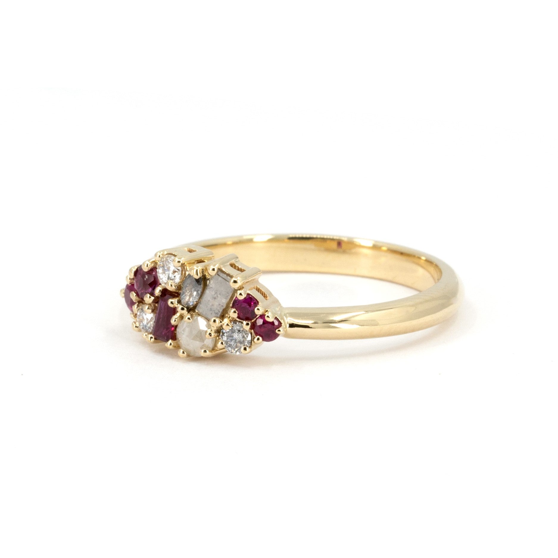 Bena Jewelry Ruby & Salt And Pepper Diamond Avalanche Ring displayed on a white surface, showcasing its one-of-a-kind yellow gold design with rubies and salt and pepper diamonds.