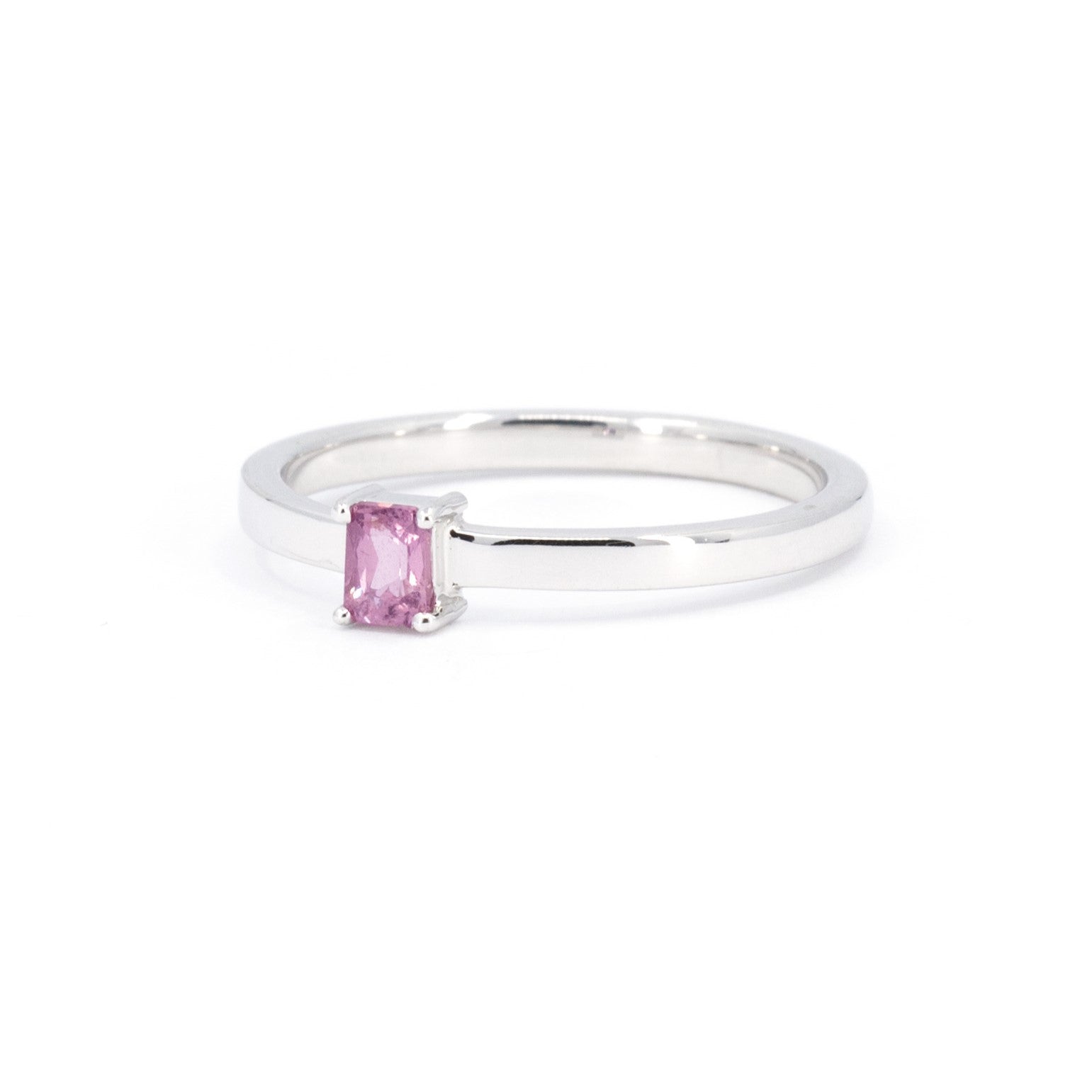 Boxy white gold ring with a vibrant pink sapphire in baguette cut, crafted by Bena Jewelry, a Montreal-based jewelry designer.