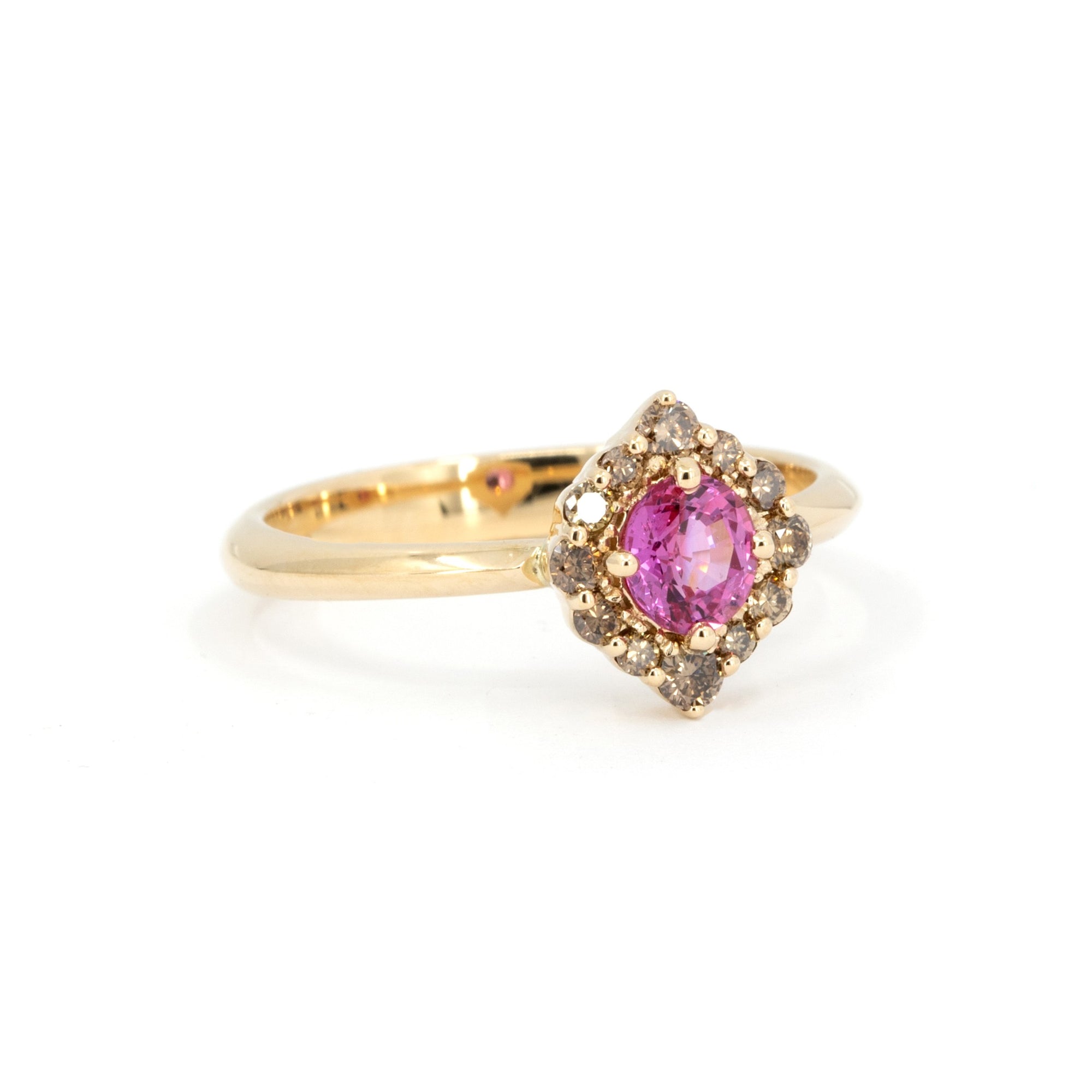 Close-up of Montreal-made pink sapphire ring with brown diamond halo, handcrafted in yellow gold by Bena Jewelry – edgy fine jewelry.
