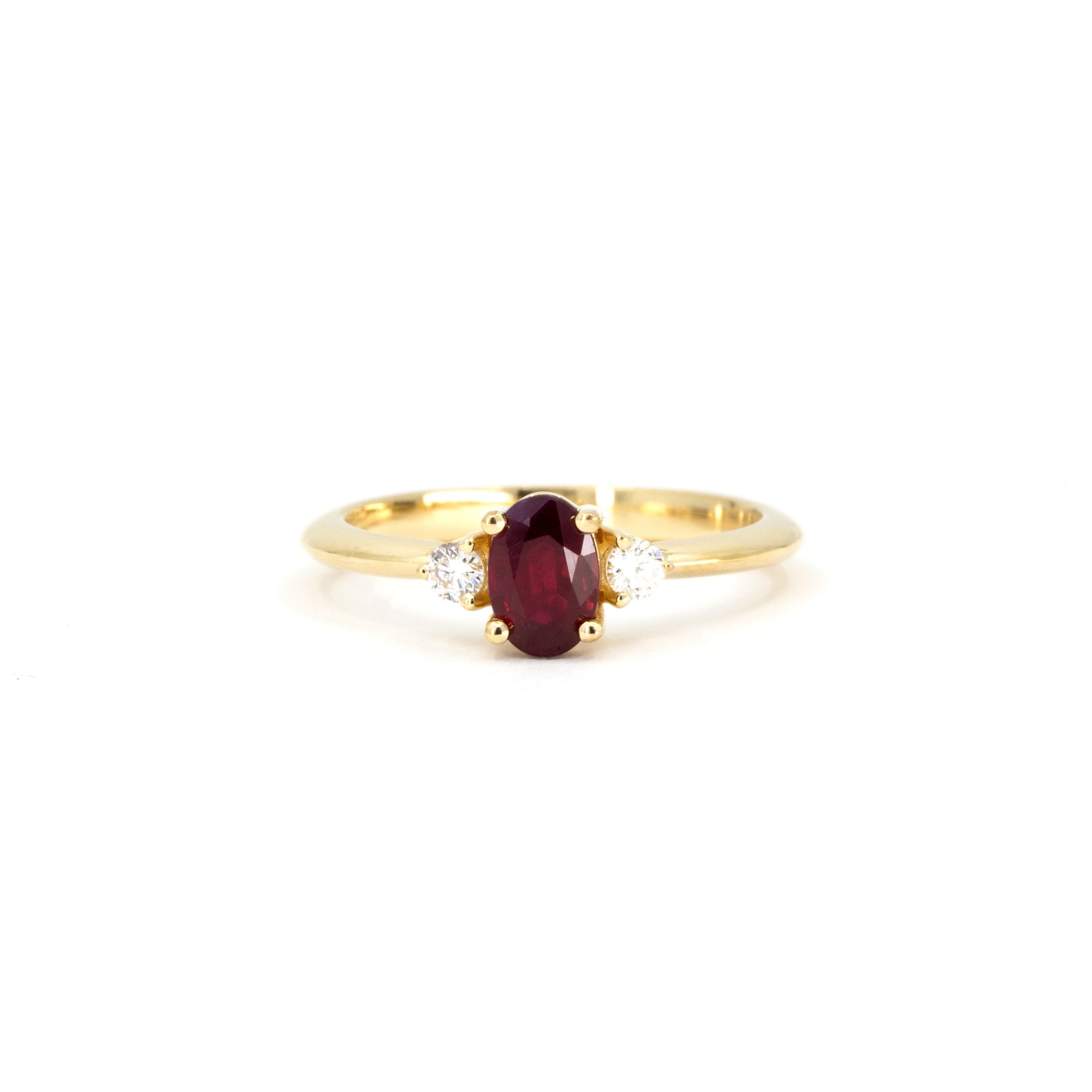 Ruby Flame Ring on white background – A classic engagement ring featuring an oval ruby and diamond accents in yellow gold. Handmade by Bena Jewelry in Montreal.