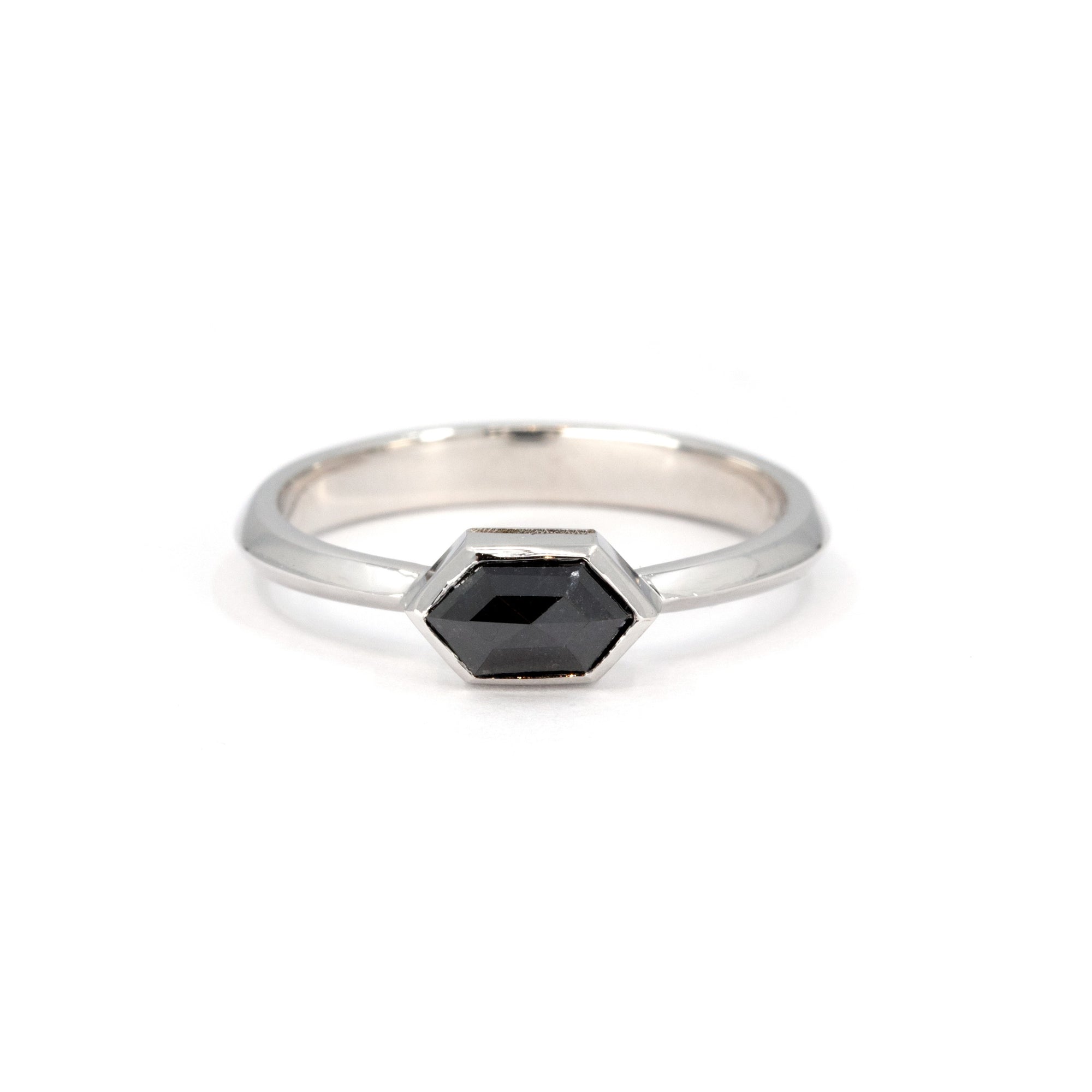 Custom-made ring featuring a hexagonal black diamond in a sleek bezel setting, crafted in white gold by Bena Jewelry, a designer jeweler from Montreal, Canada.