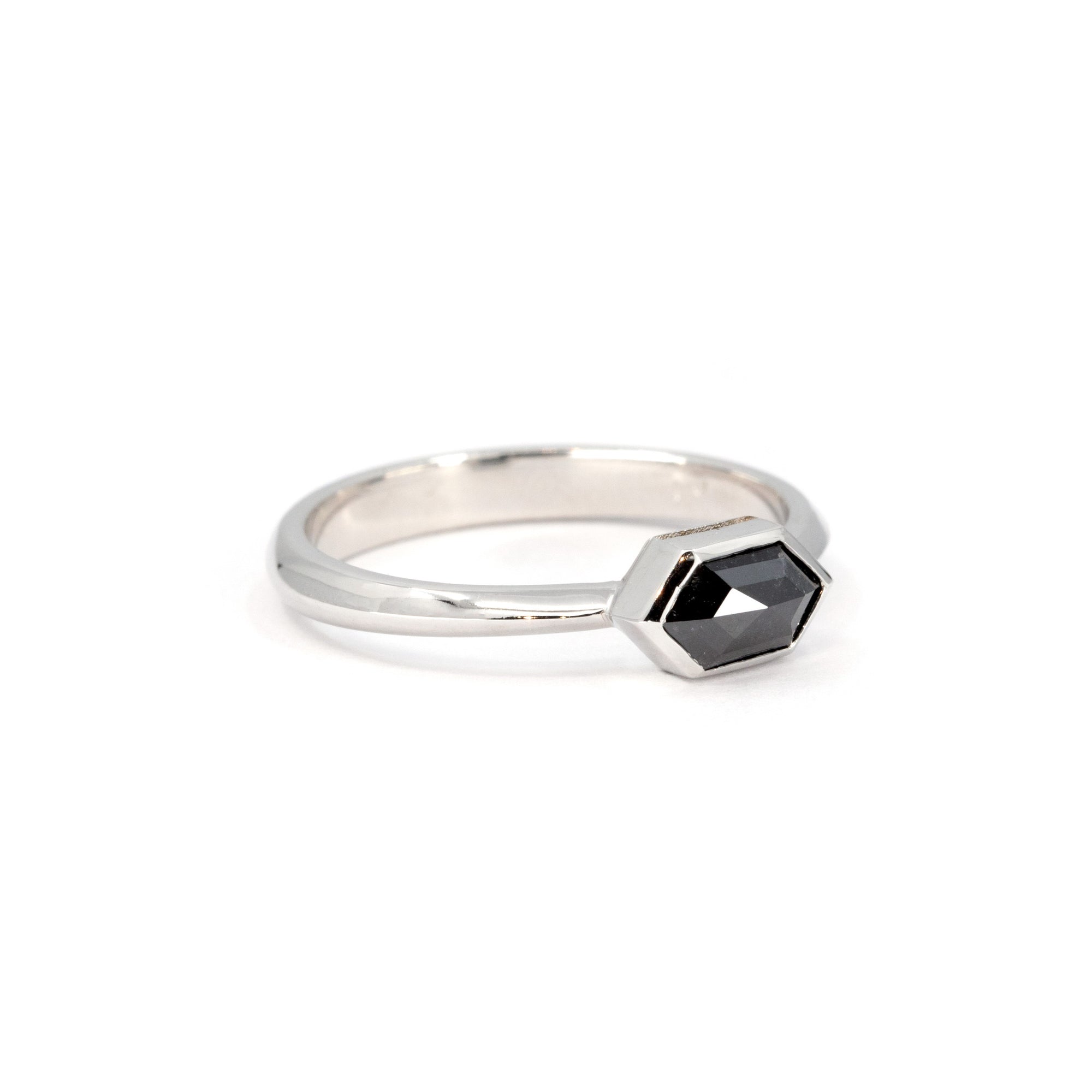 Elegant hexagonal black diamond ring in white gold, showcasing a minimalist bezel setting, designed and handcrafted by Bena Jewelry in Montreal.