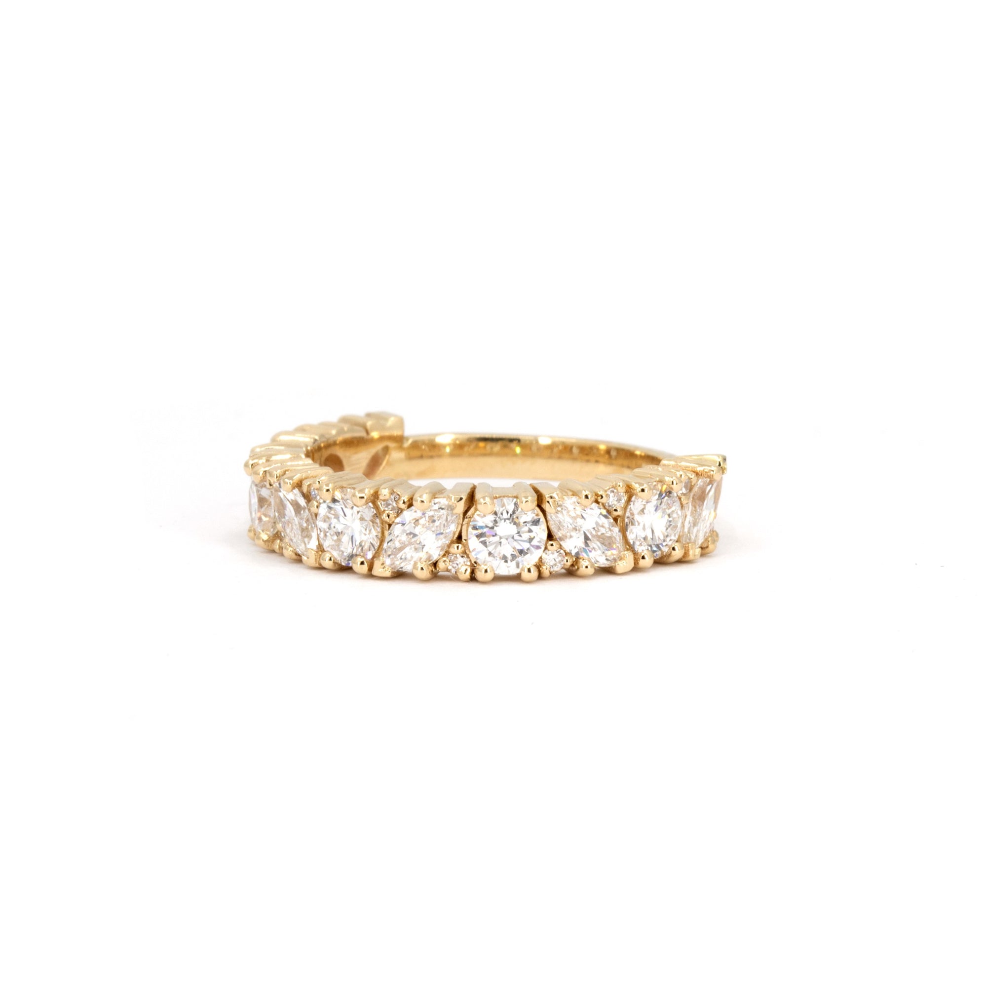 Close-up of marquise and round lab-grown diamonds set on a luxurious yellow gold eternity  Bena Jewelry wedding band.