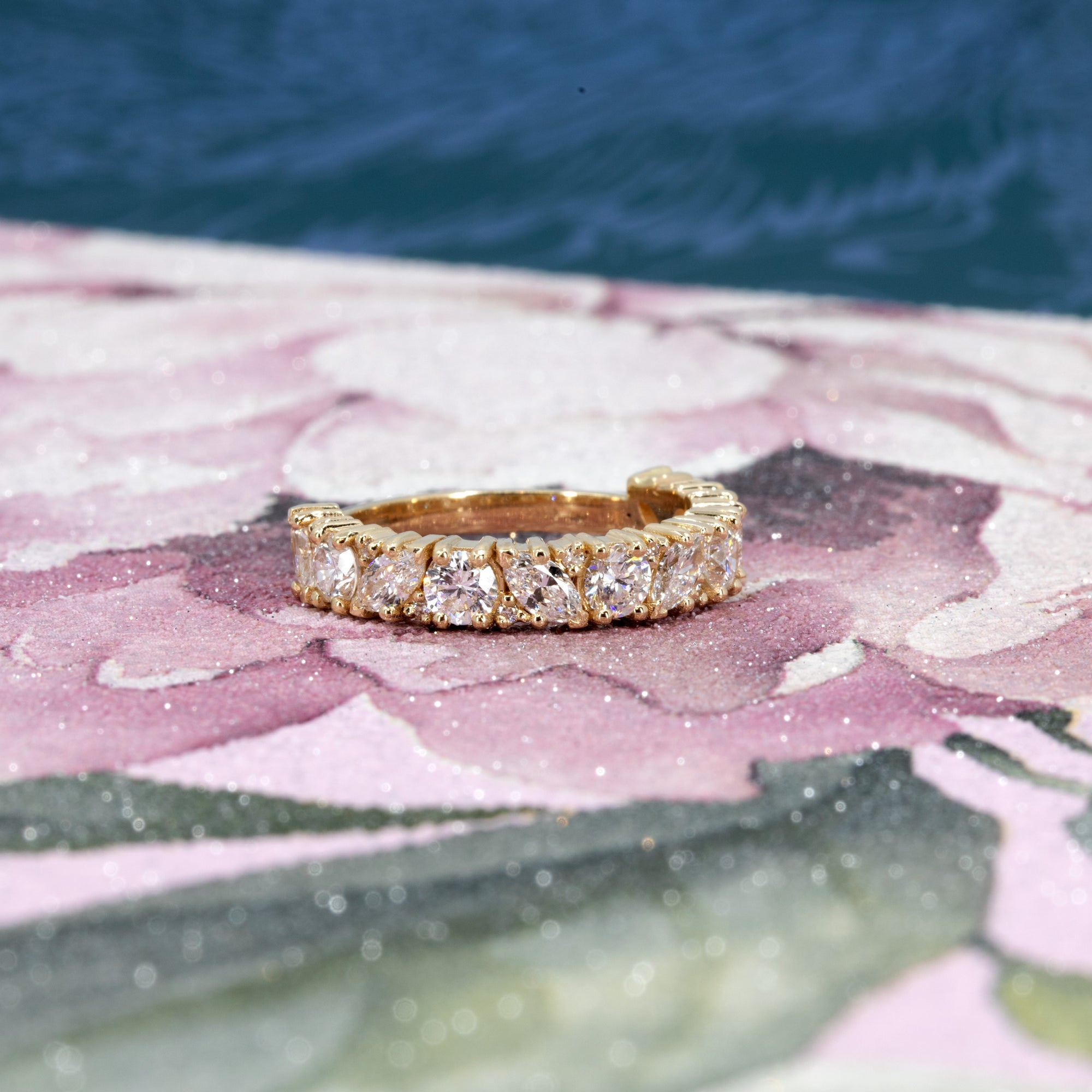 Full view of a bold yellow gold full eternity wedding band with a mix of marquise and round lab-grown diamonds totaling 1.82 carats made by  Bena Jewelry in Montreal.