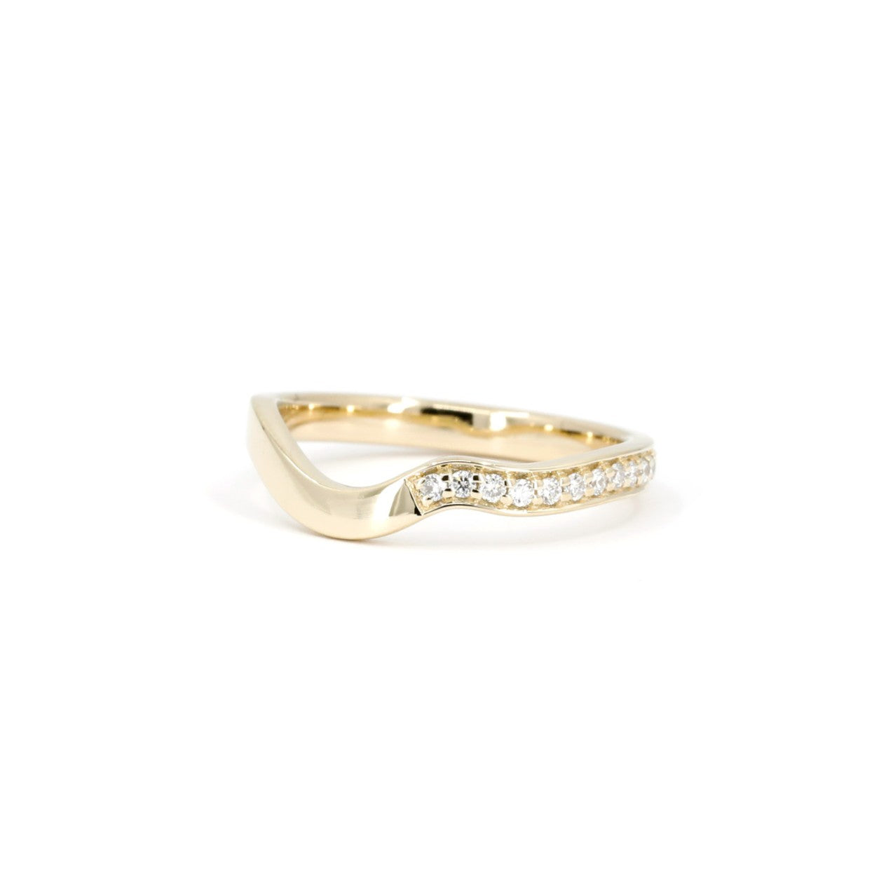 Top view of a wavy yellow gold band featuring a row of pavé-set round diamonds. Minimalist fine jewelry crafted by Bena Jewelry in Montreal.