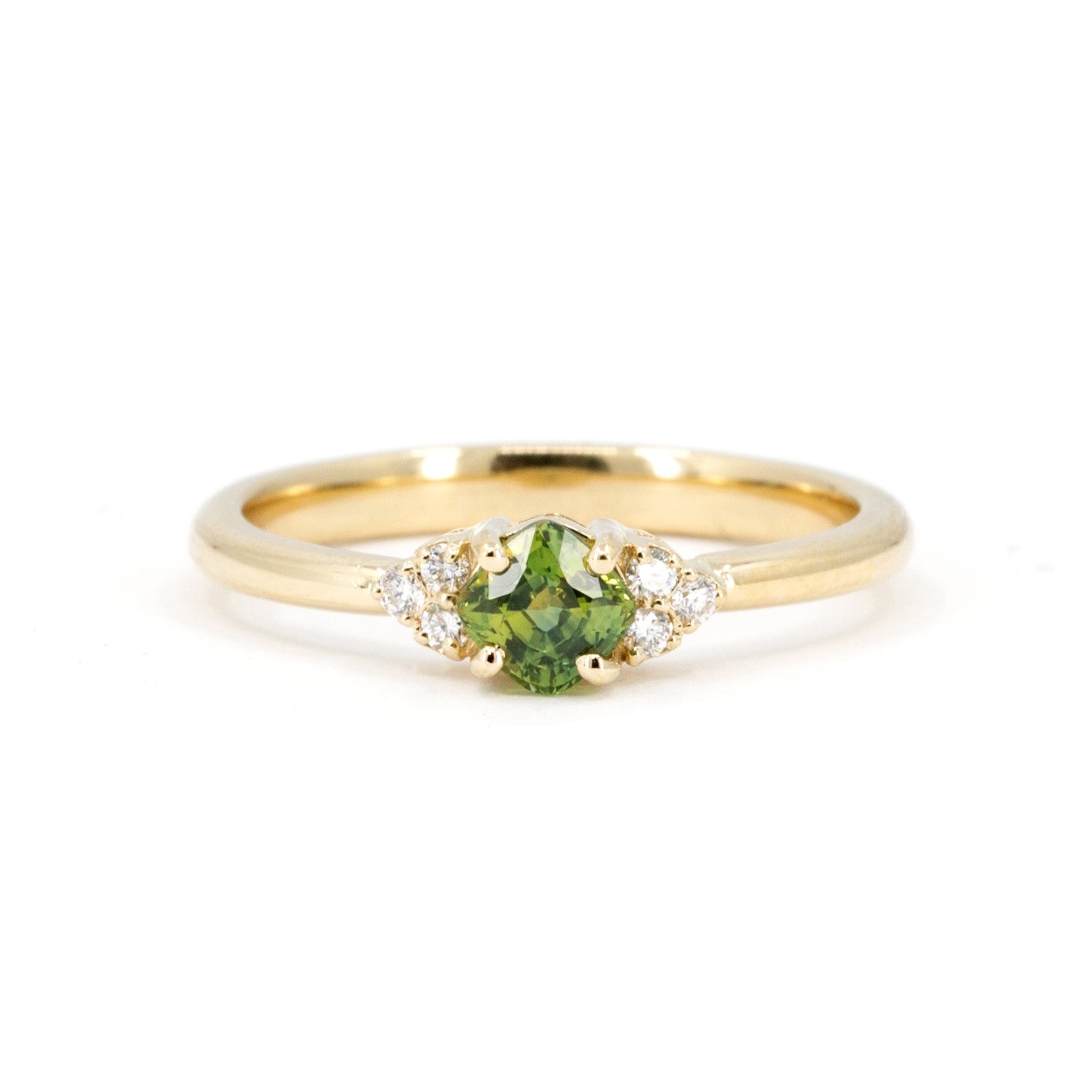 Cushion-cut green sapphire engagement ring with side diamonds in a timeless yellow gold setting. Made in Montreal by Bena Jewelry, fine bridal jewelry designer.