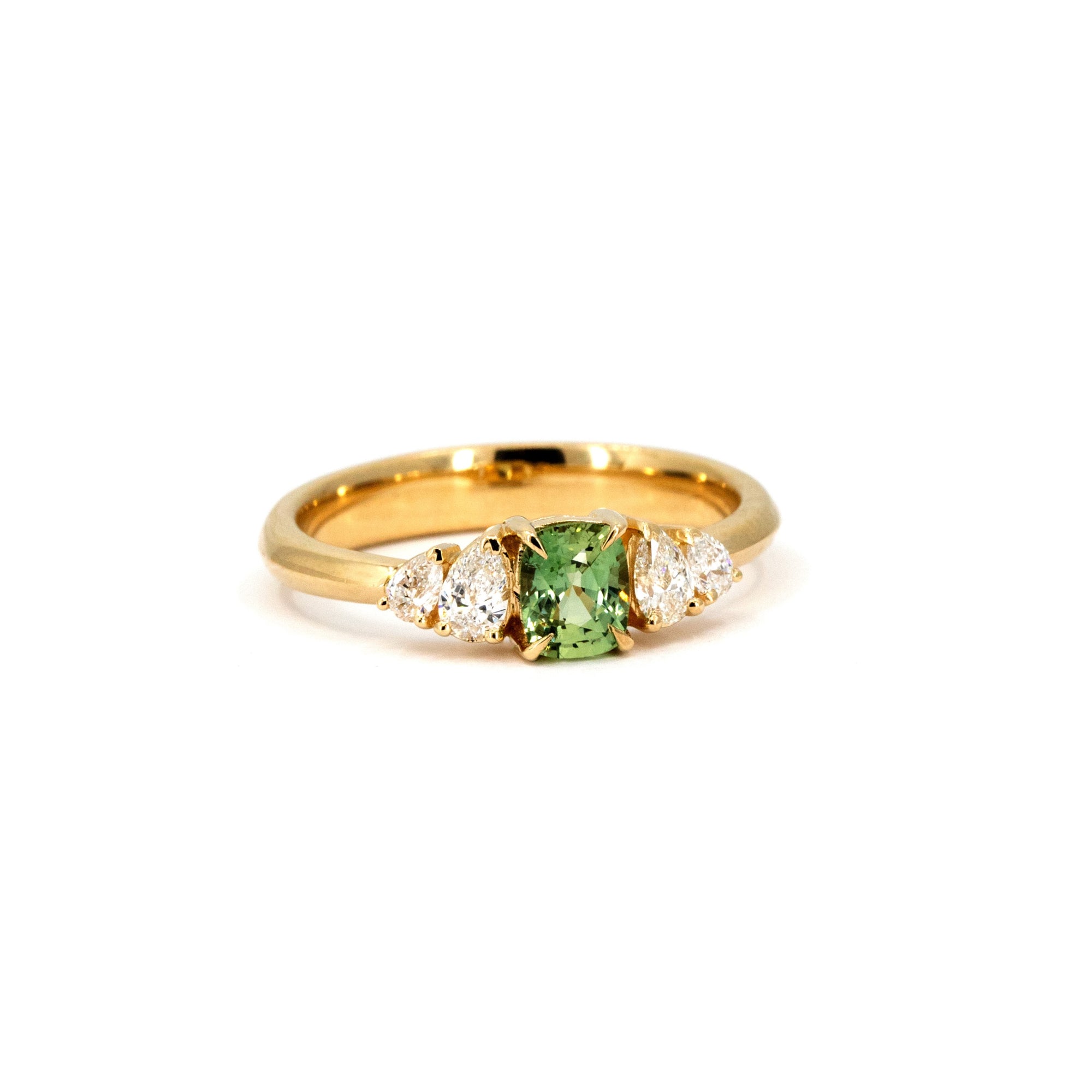Designer ring featuring a vivid green cushion sapphire and lab-grown pear diamonds, mounted on yellow gold. Handmade in Montreal by Bena Jewelry, Canada.