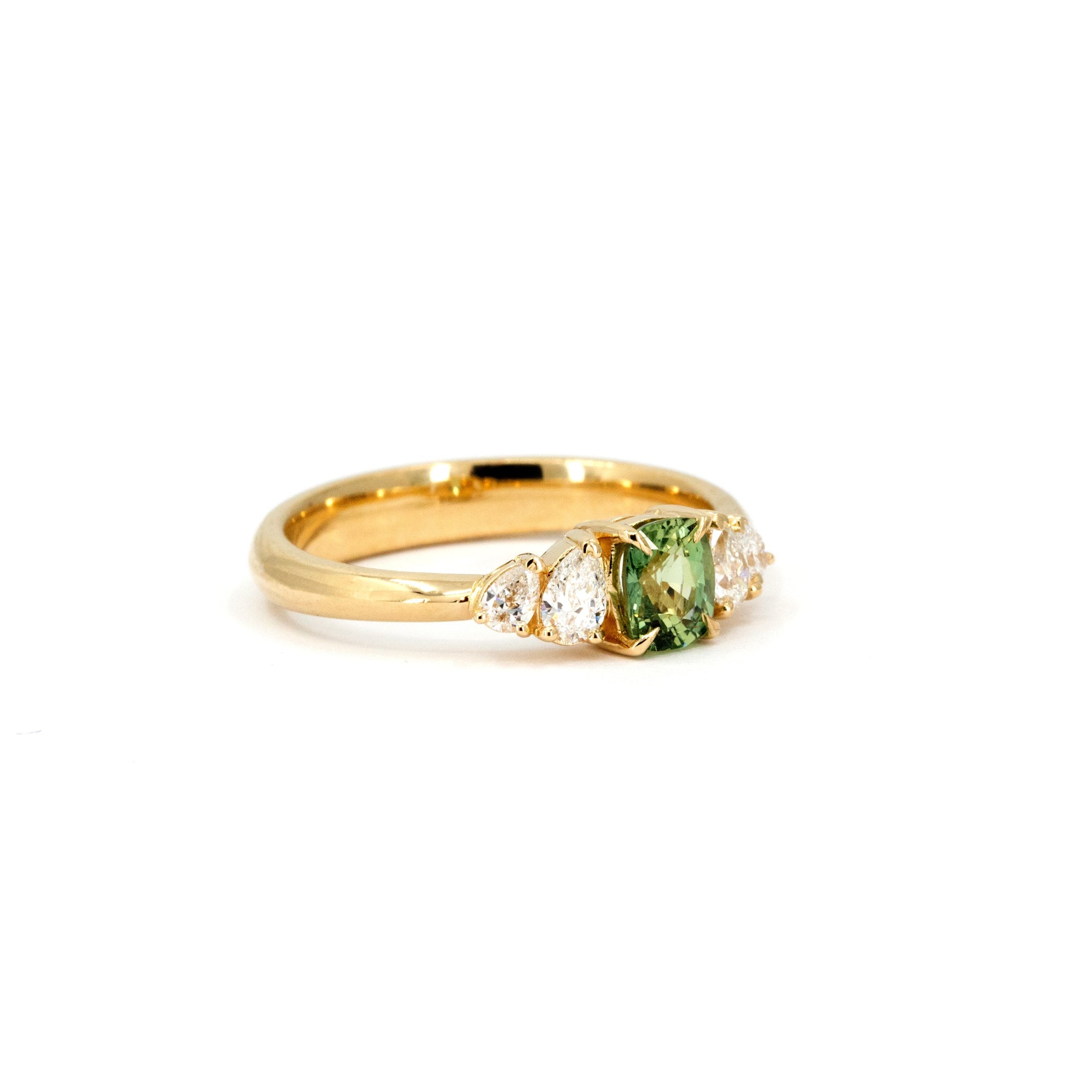 Side view of Cushion-cut green sapphire ring with lab-created pear diamonds in yellow gold. Designed and made in Montreal by Bena Jewelry, Canada.