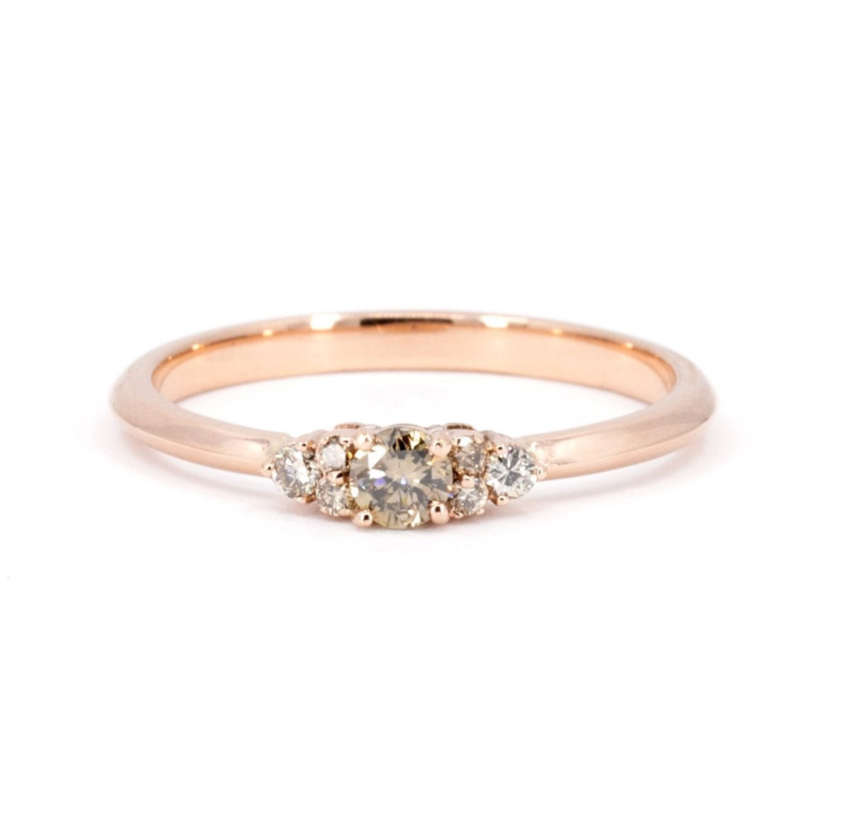 Custom engagement ring by Bena Jewelry, featuring a golden champagne diamond with round side diamonds. Set on a rose gold band, displayed on a clean white background. A timeless design crafted in Montreal.