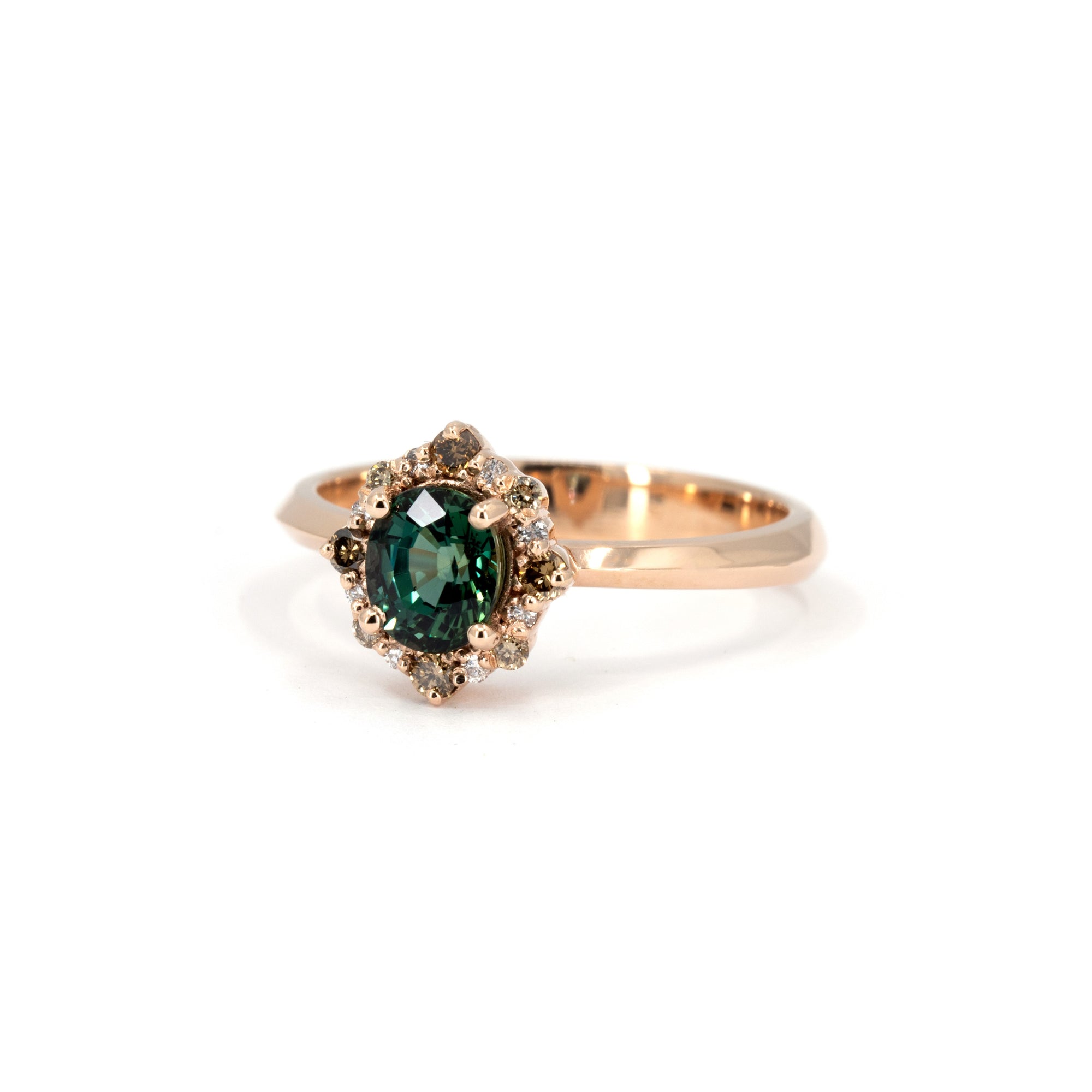 Teal sapphire halo ring in rose gold with mixed diamonds, handcrafted by Bena Jewelry, shown from a top-down angle on a white background.