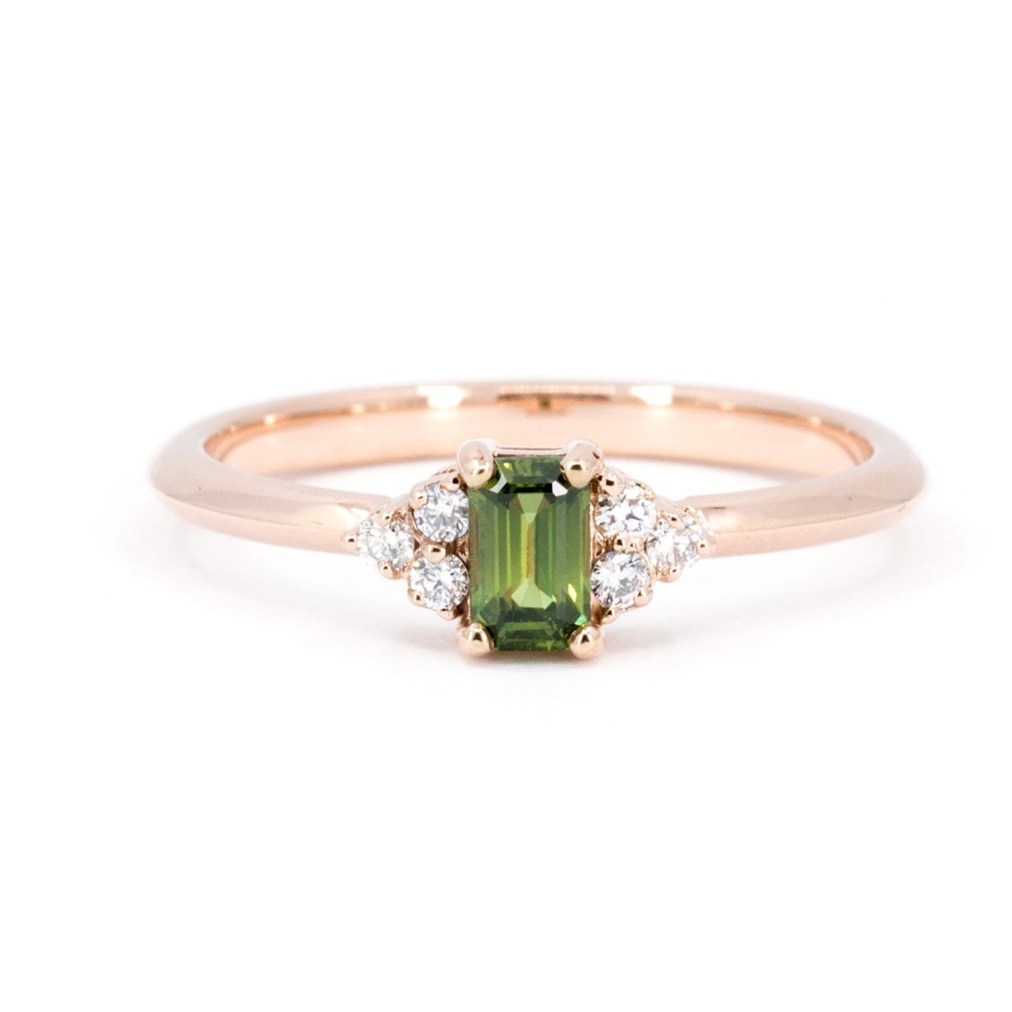 Désir Baguette Green Sapphire Ring in rose gold featuring a deep green sapphire and diamond accents by Bena Jewelry photographed on a clean white background custom-made in Montreal