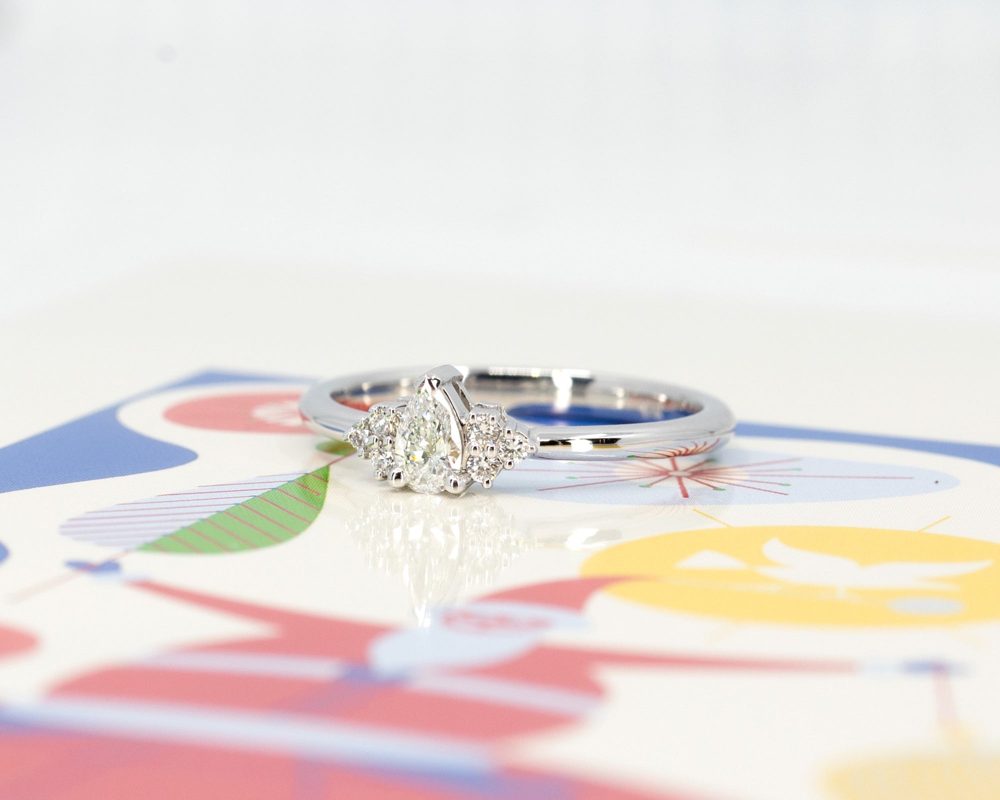 Close-up of the white gold pear diamond engagement ring, showcasing its delicate and timeless design.