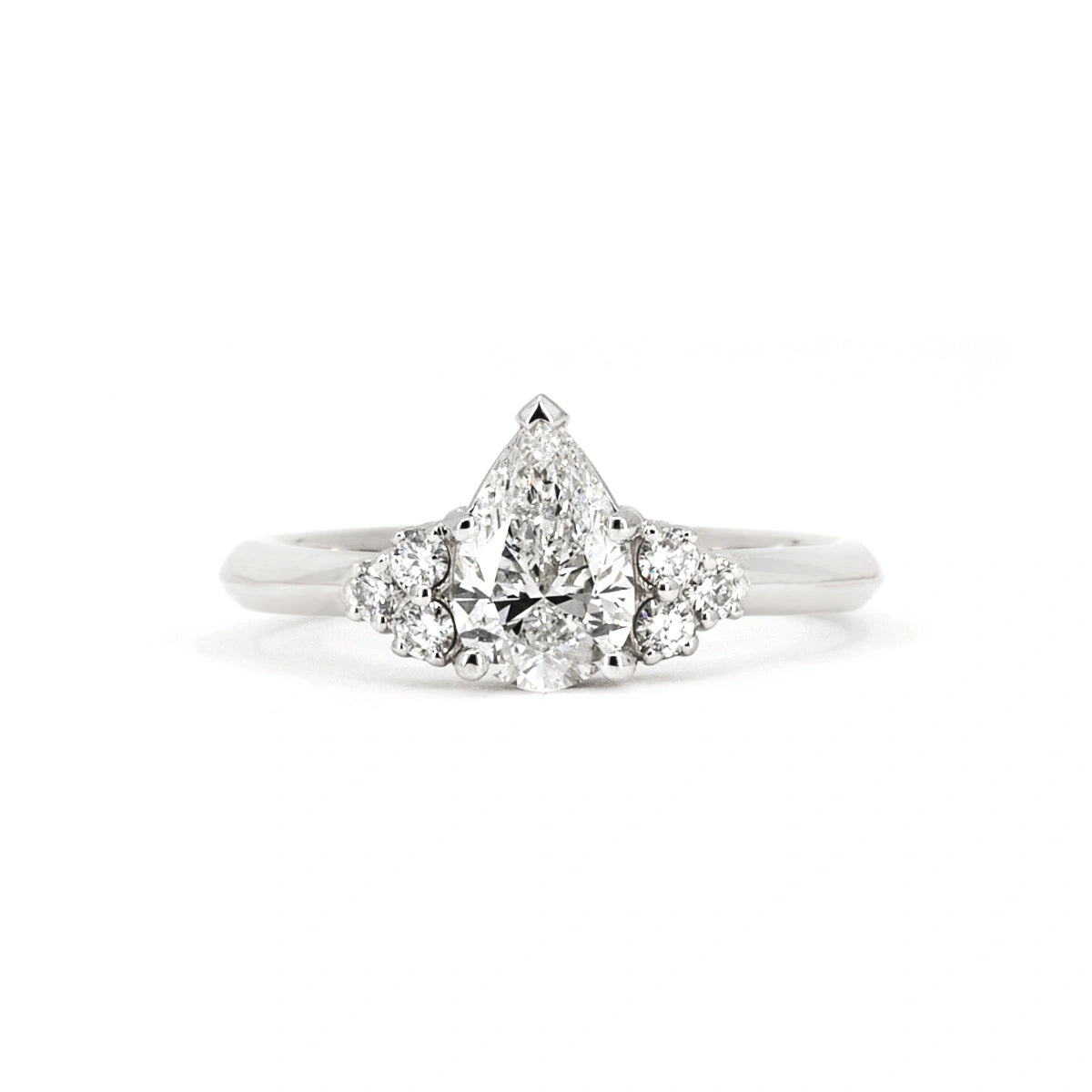 White gold engagement ring with a central pear-shaped diamond and side diamonds, custom-made by Bena Jewelry in Montreal, Canada.