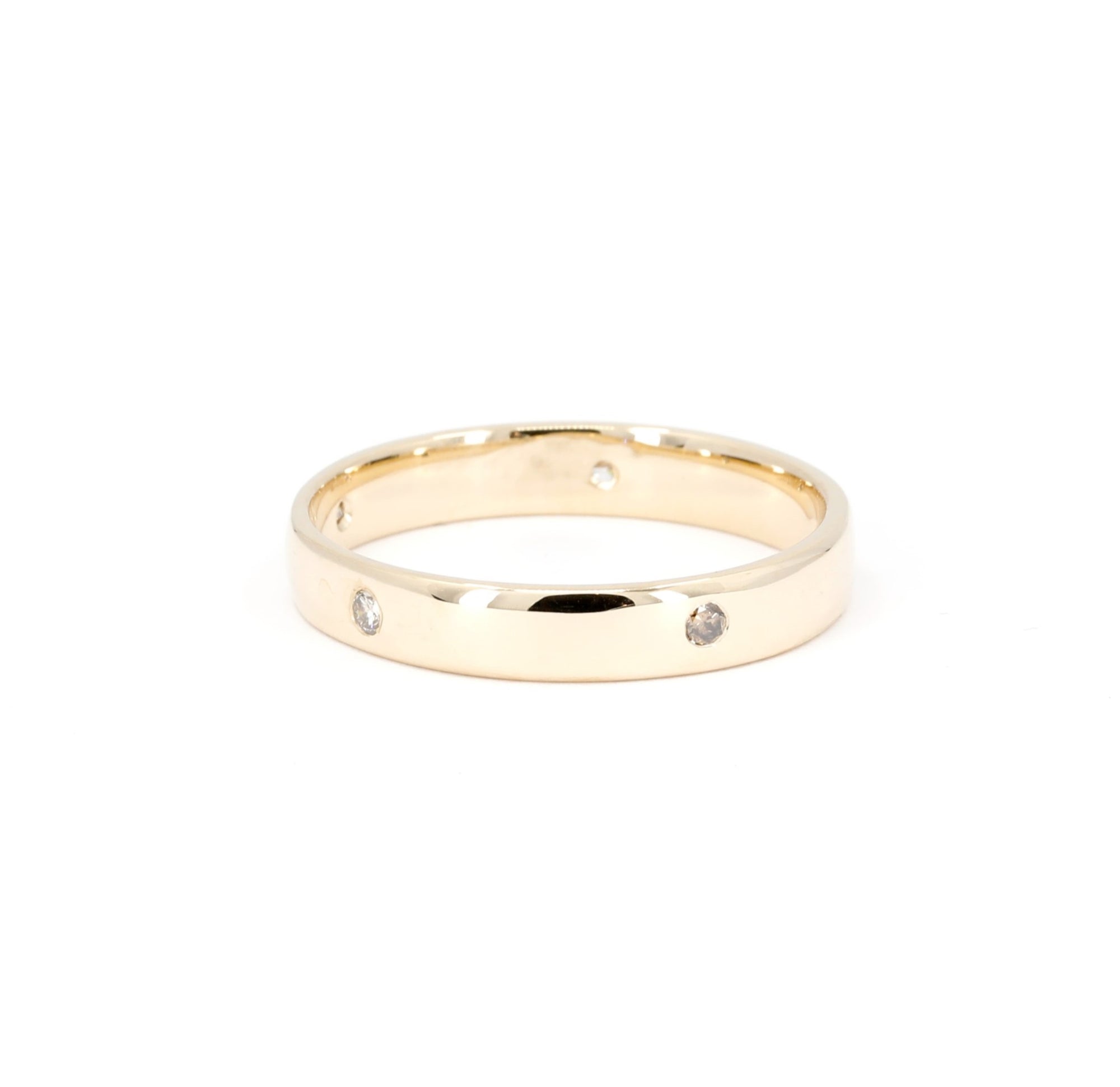 Gold wedding band with bezel-set diamonds, handmade in Montreal by Bena Jewelry, a timeless men’s wedding ring.