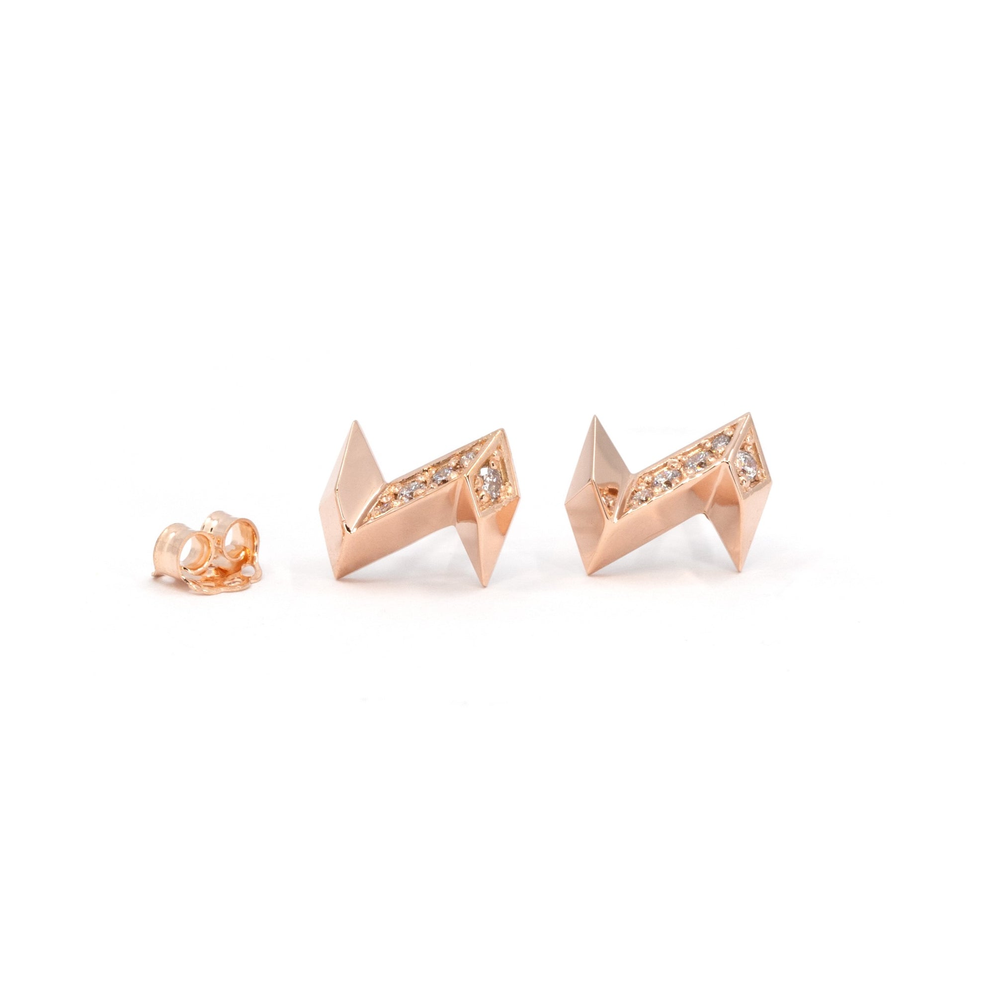 Lightning bolt earrings in rose gold with laboratory diamonds. This designer jewel is seen here against a white background, photographed from the front. The earrings are a creation of independent Canadian brand Bena Jewelry and are available at Ruby Mardi, a unique jewelry store in Canada. 