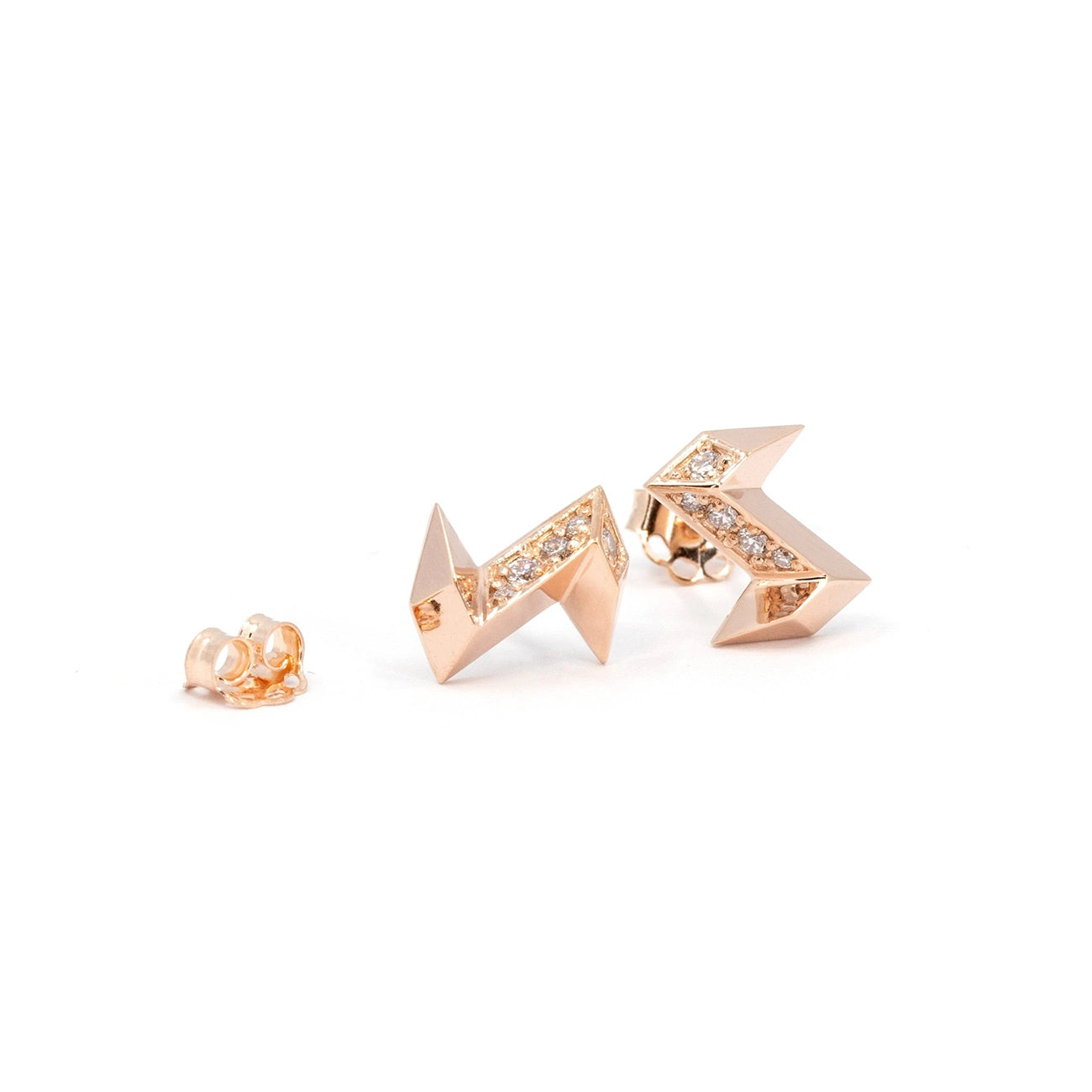 Lightning bolt earrings in rose gold with laboratory diamonds. This designer jewel is seen here against a white background. We see a matching butterfly in 14-carat rose gold, and the two earrings are presented at different angles. The earrings are a creation of independent Canadian brand Bena Jewelry.