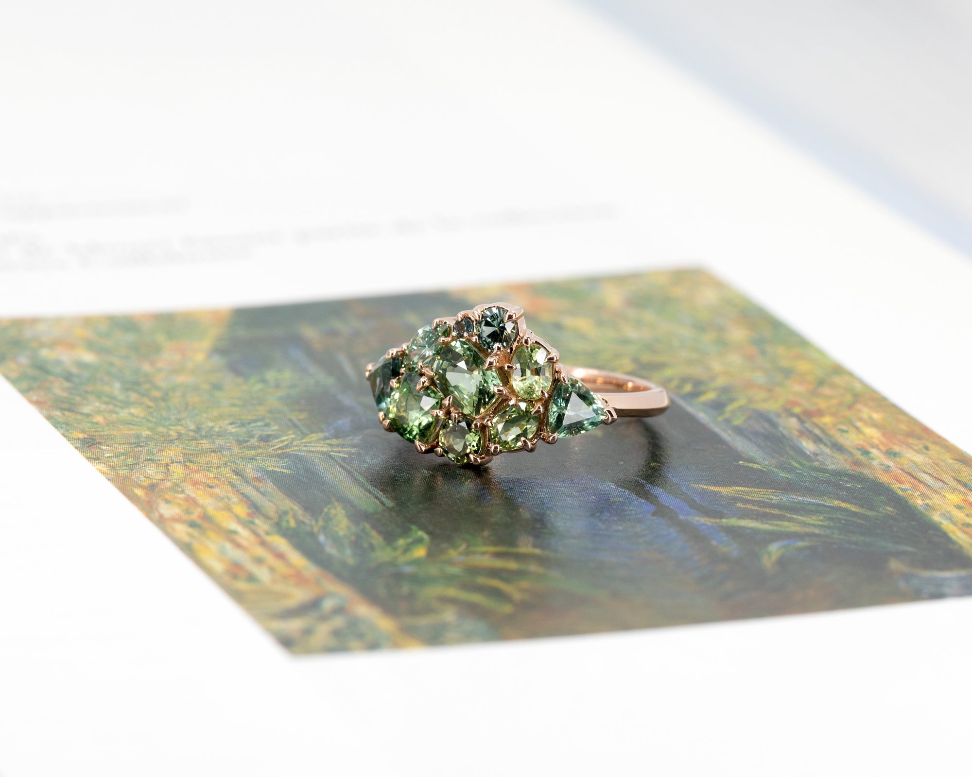 Close-up: Focuses on the vibrant green tones of the gemstones and the smooth finish of the rose gold. Made in Montreal, Canada, by independent designer Bena Jewelry.