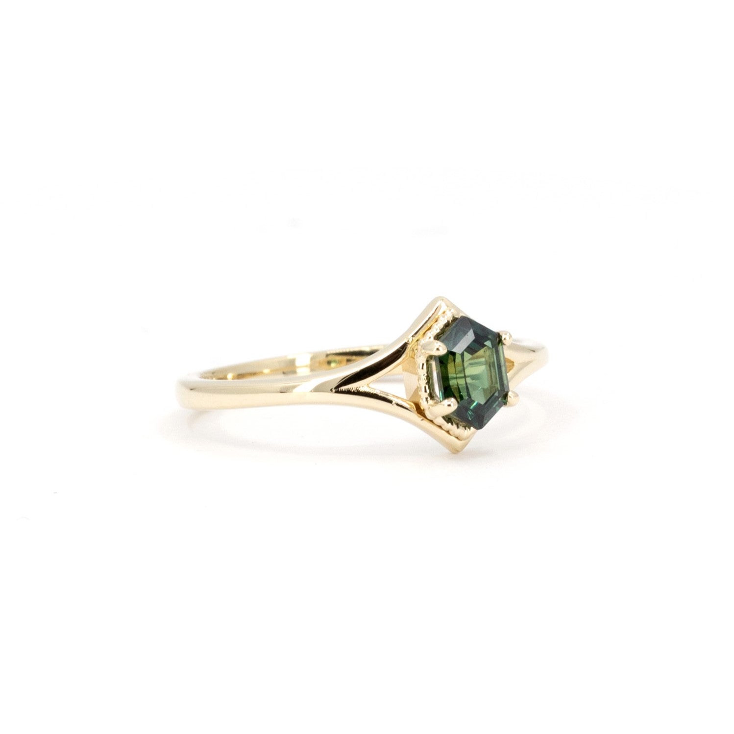 Side angle of the Adorn Hexagonal Green Sapphire Ring by Bena Jewelry, emphasizing the precision of the bezel setting and the sleek gold design. Crafted in Montreal, Canada, this custom jewelry piece exemplifies refined artistry.