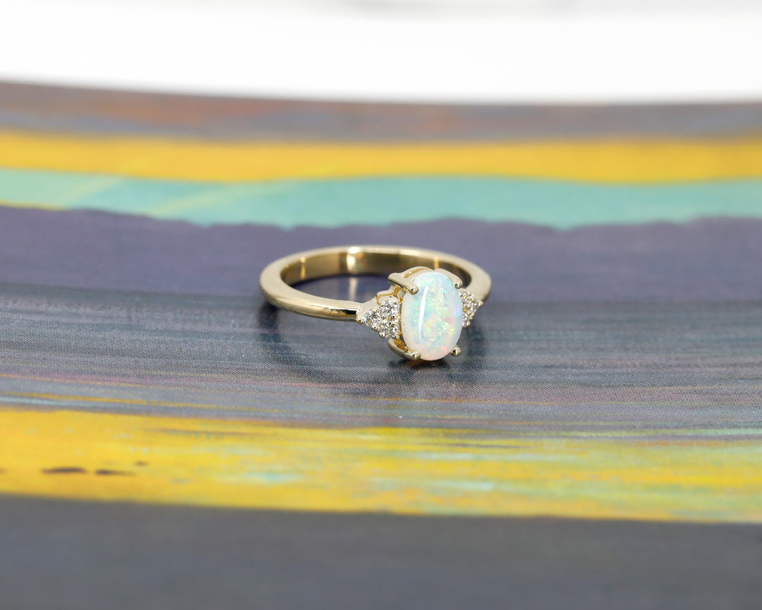 side view of oval shape opal gemstone and diamond yellow gold engagement ring custom made in montreal by bena jewelry