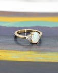 side view of oval shape opal gemstone and diamond yellow gold engagement ring custom made in montreal by bena jewelry