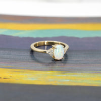 side view of oval shape opal gemstone and diamond yellow gold engagement ring custom made in montreal by bena jewelry