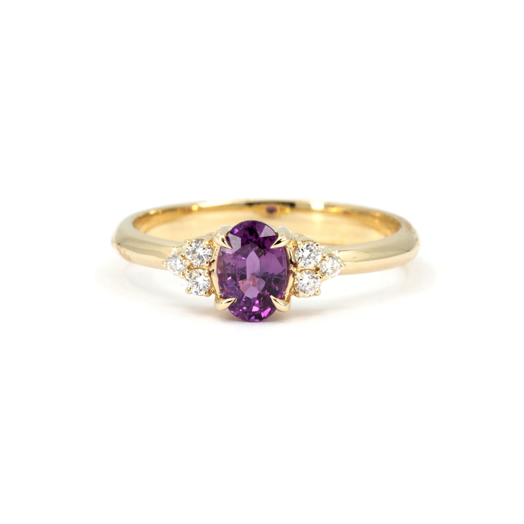 Desir Ring with an oval purple-pink sapphire and diamond accents, set in yellow gold. A handcrafted engagement ring by Bena Jewelry, Montreal.