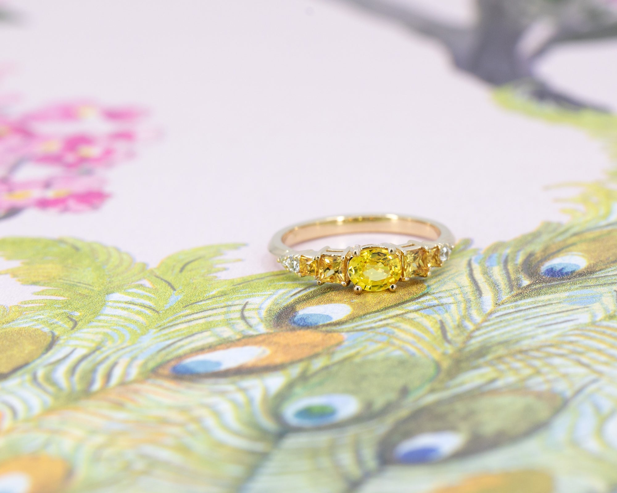 Detailed view of the yellow gold diamond band, complementing the engagement ring, displayed against a floral background.