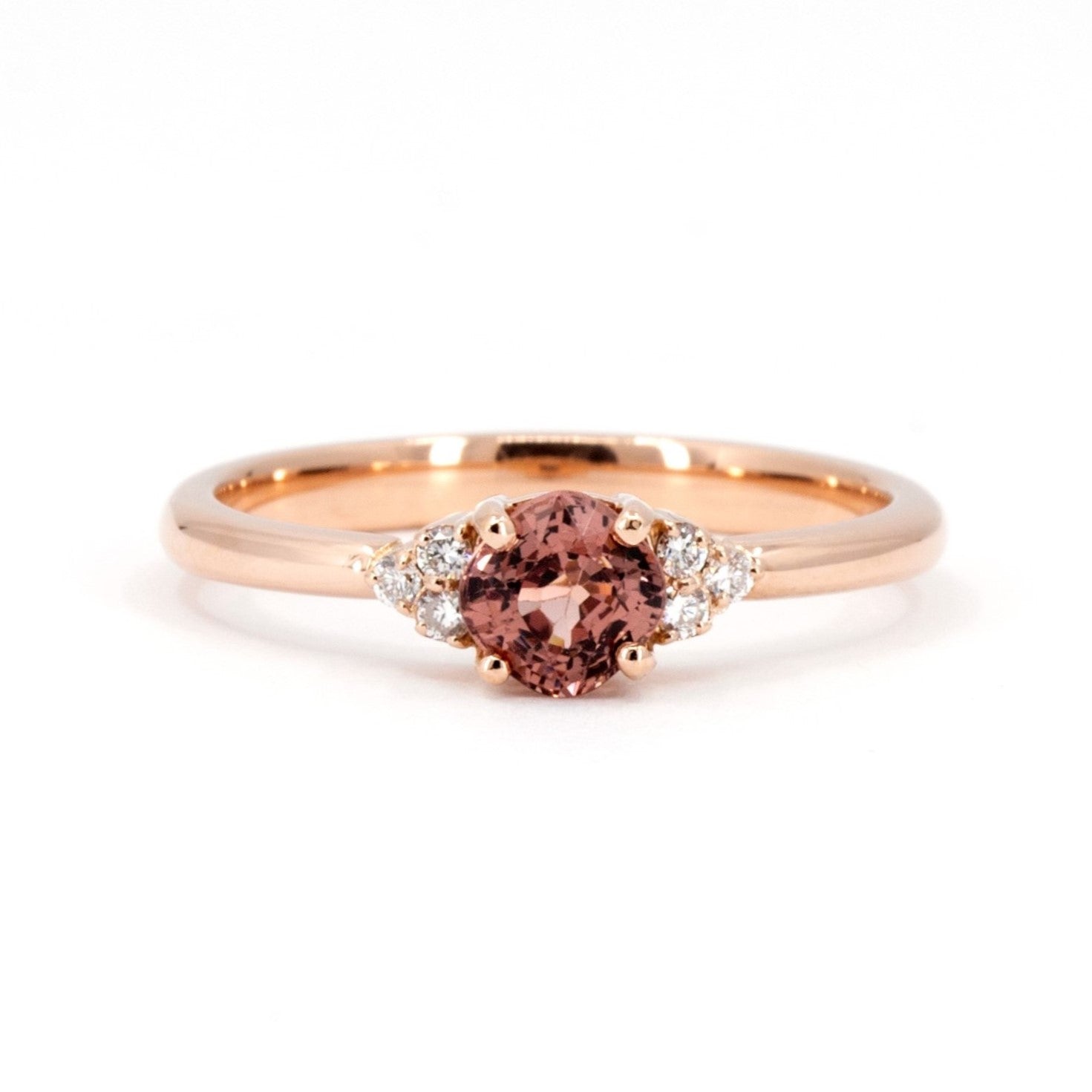 Désir ring in rose gold featuring a cushion-cut peach spinel with soft cinnamon hues, accented by side diamonds. A unique engagement ring handmade in Montreal by Bena Jewelry.