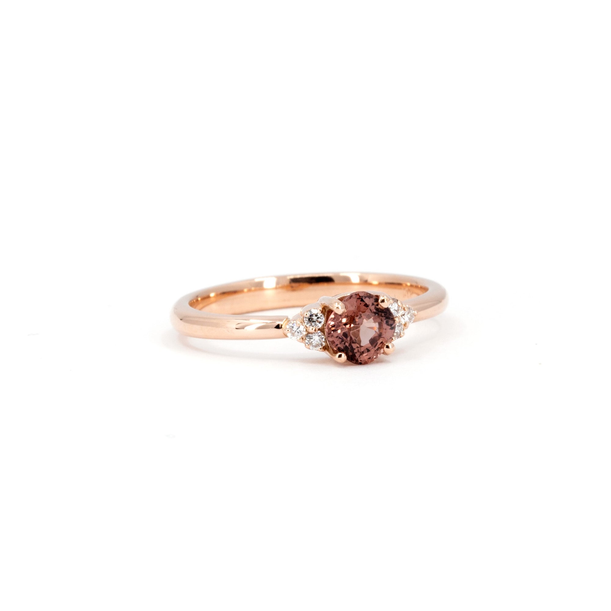 Close-up of the Désir Cushion Peach Spinel Ring, showcasing its delicate rose gold setting, vibrant spinel center stone, and sparkling diamond accents. Designed by Bena Jewelry.