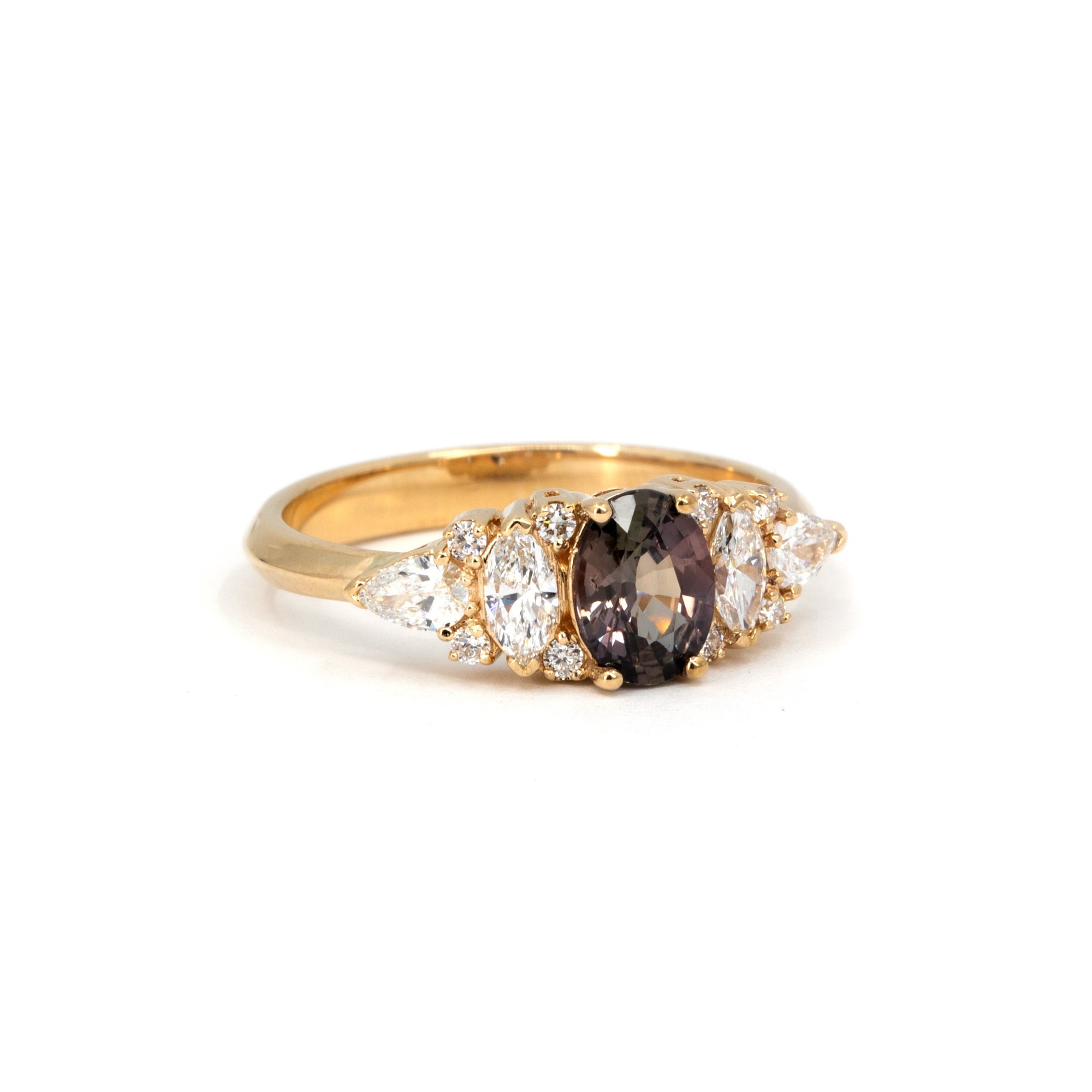 Handcrafted peacock sapphire ring by Bena Jewelry, made in Montreal, featuring asymmetrical white diamonds and color-changing center stone on a clean white backdrop.