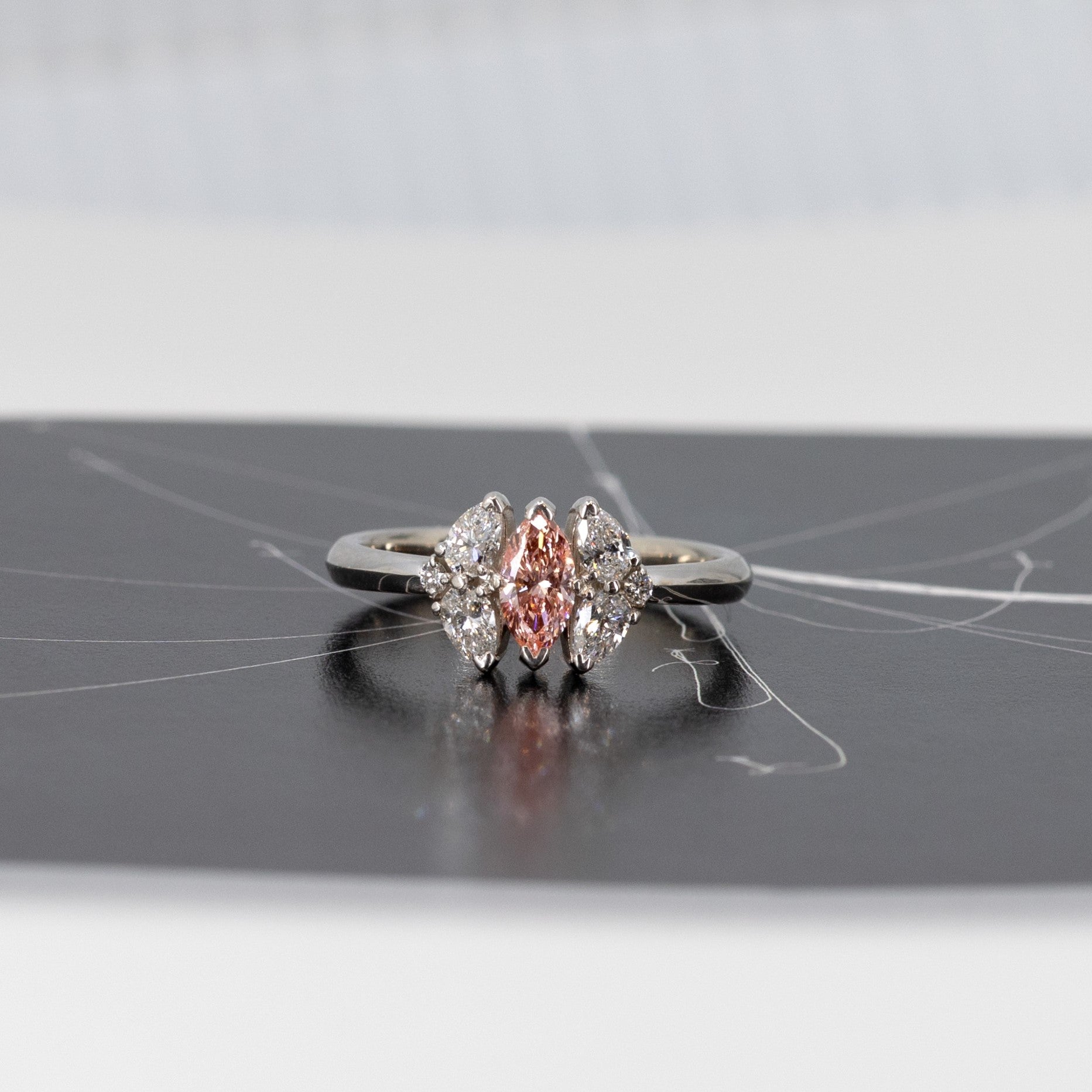 Front view of the Salmon Pink Diamond Engagement Ring, designed by Bena Jewelry in Montreal – A bespoke fine jewelry creation with a warm-toned pink marquise diamond and pear-cut diamonds, crafted in white gold or platinum.