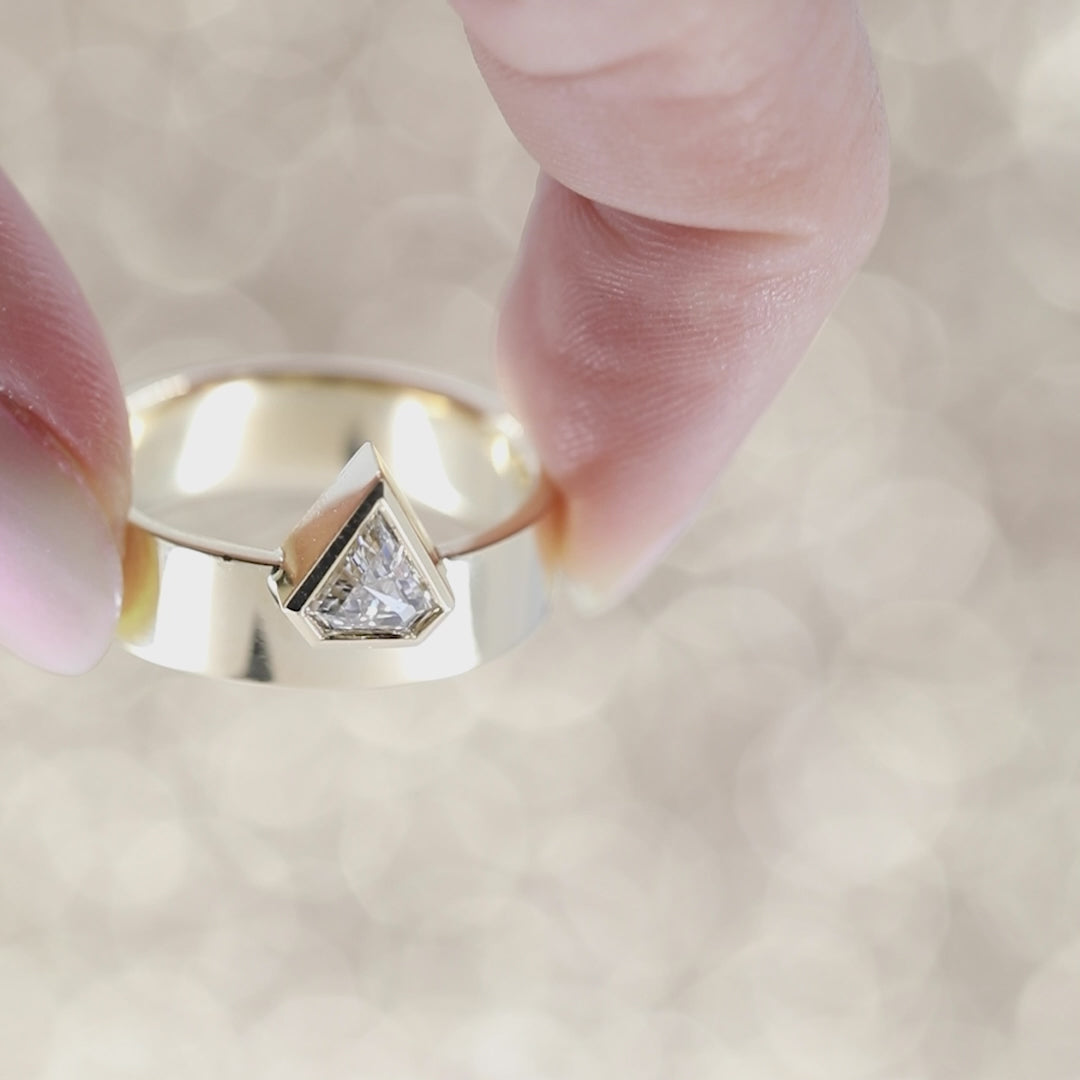 A short video featuring two yellow gold rings with diamonds filmed in front of a background of gold glitter. The jewels are meant to be worn together, staked. The first ring is a wide, thick gold band topped with a pentagonal laboratory diamond. The matching band features small round brilliant diamonds. This is a bold set created in Montreal by independent brand Bena Jewelry.