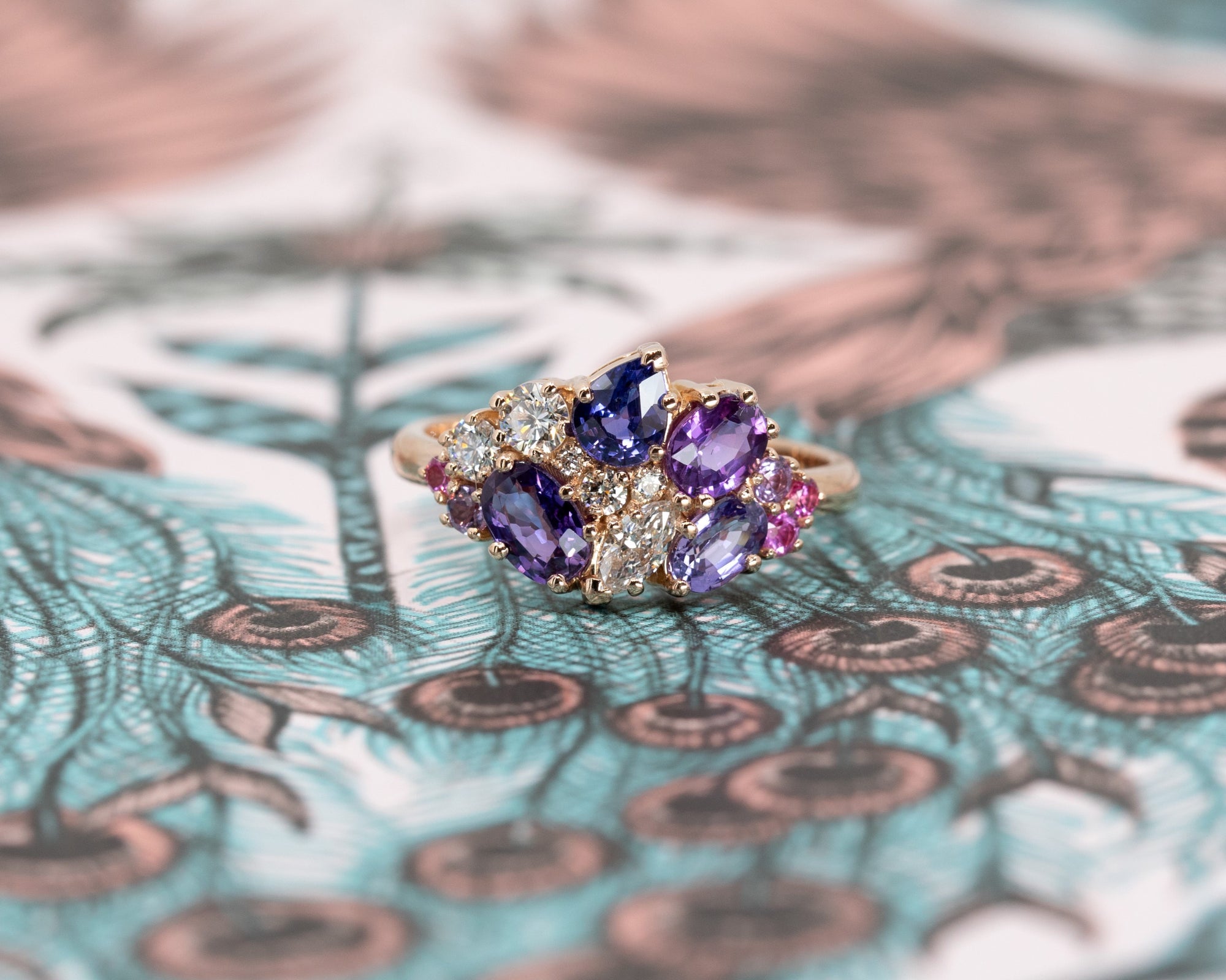 Close-up: Focuses on the vibrant hues of the sapphires and the sparkle of the diamonds against the yellow gold. Made by Bena Jewelry, Montreal, Canada.
