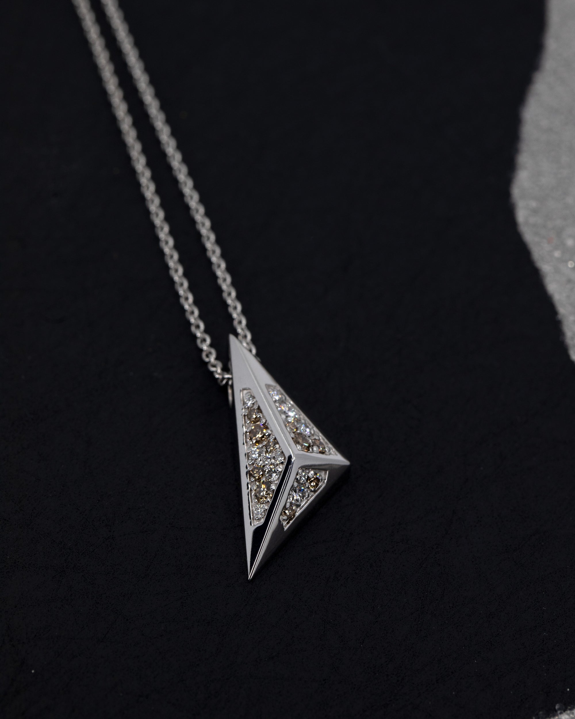 Modern pyramidal pendant in white gold with lab-grown diamonds, set against a dark background. Unique designer jewelry by Bena Jewelry, handmade in Montreal.