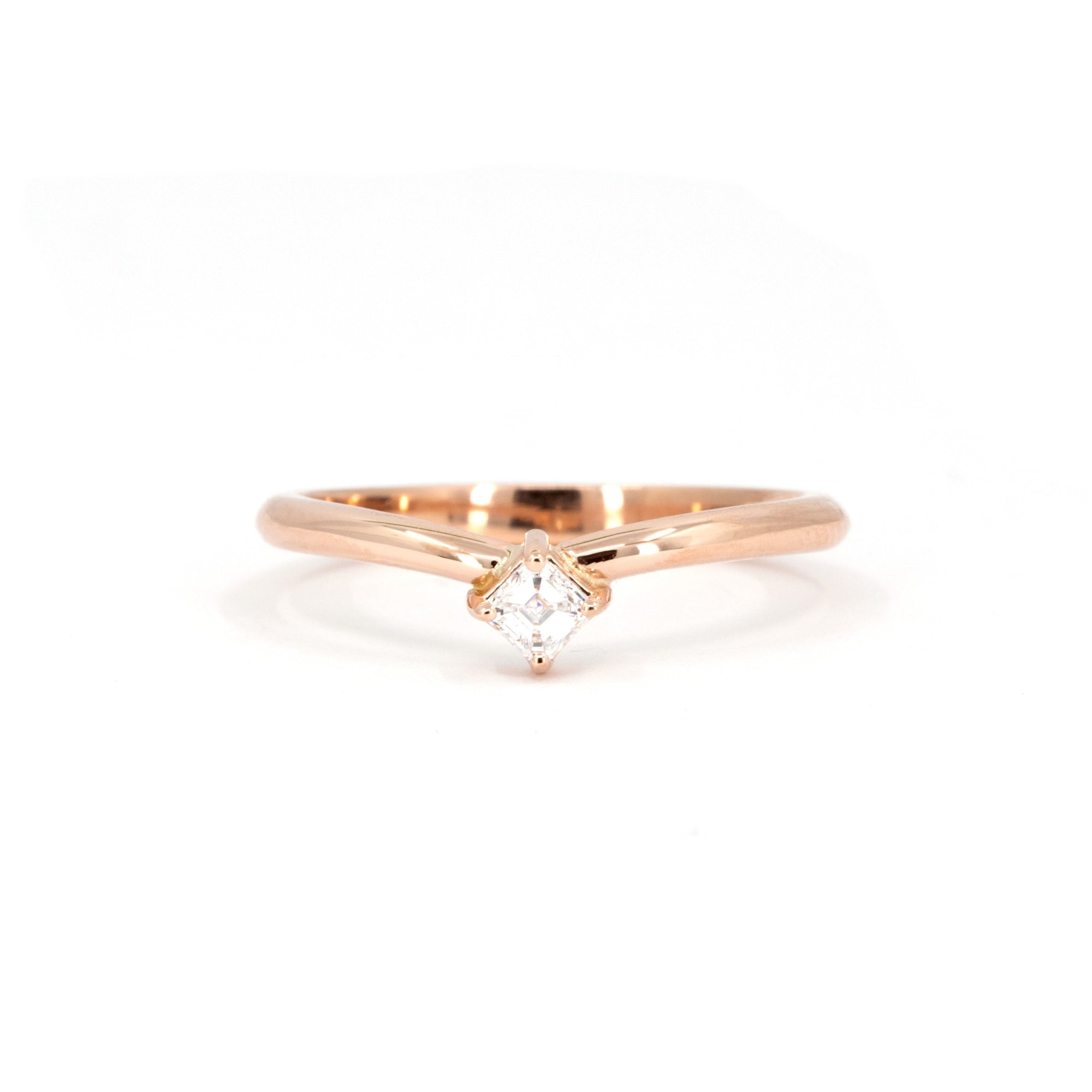 Curved rose gold ring with Asscher-cut diamond on white background, modern sculptural design, elegant and minimalist fine jewelry, by the desinger Bena Jewelry.
