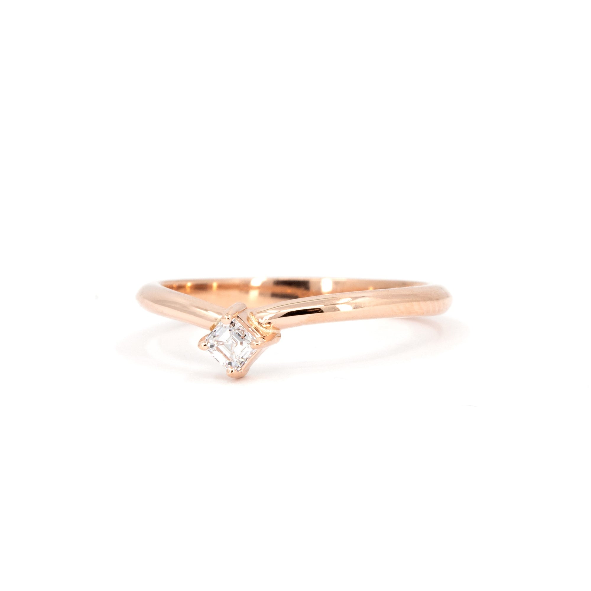 Rose gold diamond ring with curved band, featuring an Asscher-cut diamond on a white background, edgy design by Bena Jewelry.