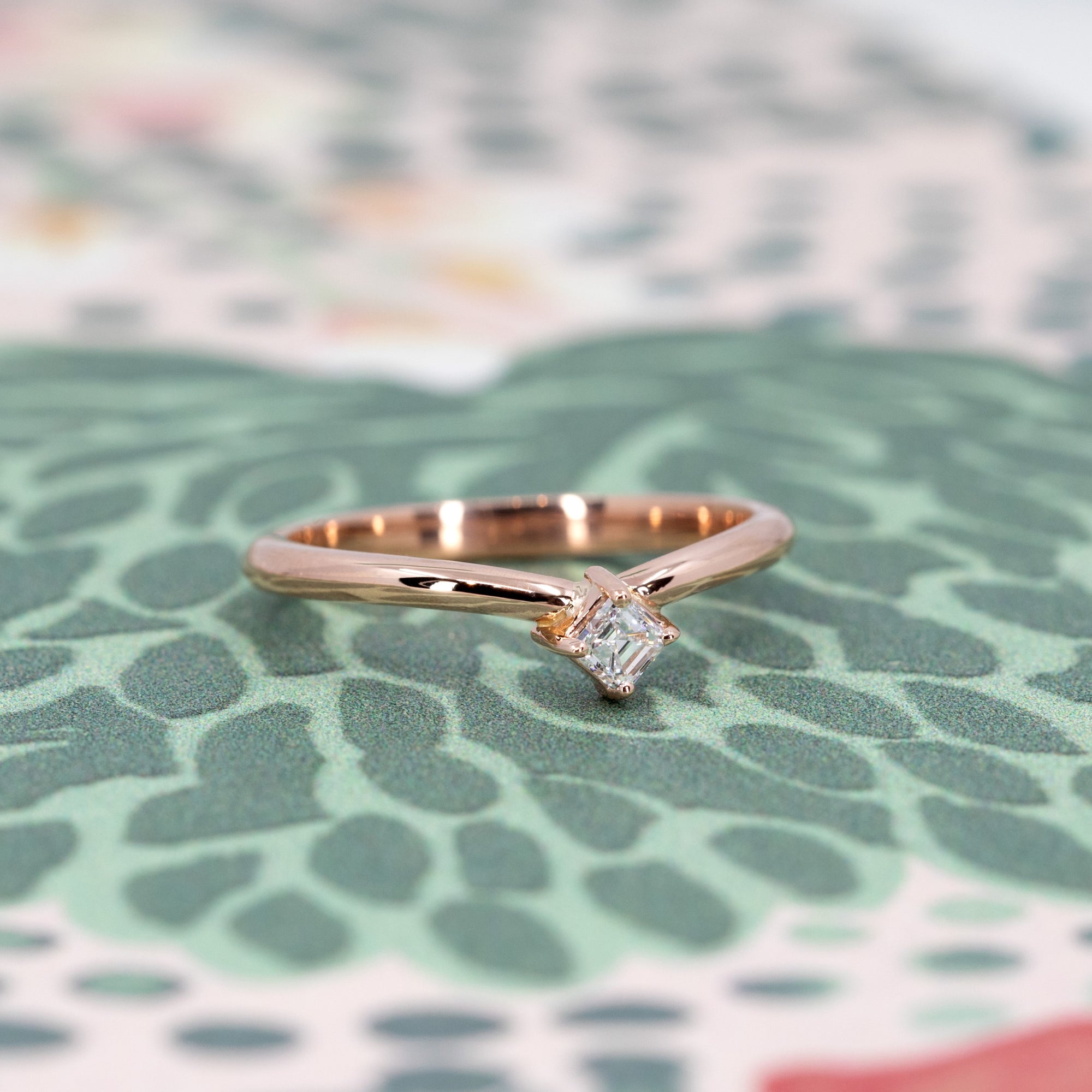 Side view of curved rose gold ring with Asscher diamond, a refined and minimalist fine jewelry piece by Bena Jewelry, Montreal.