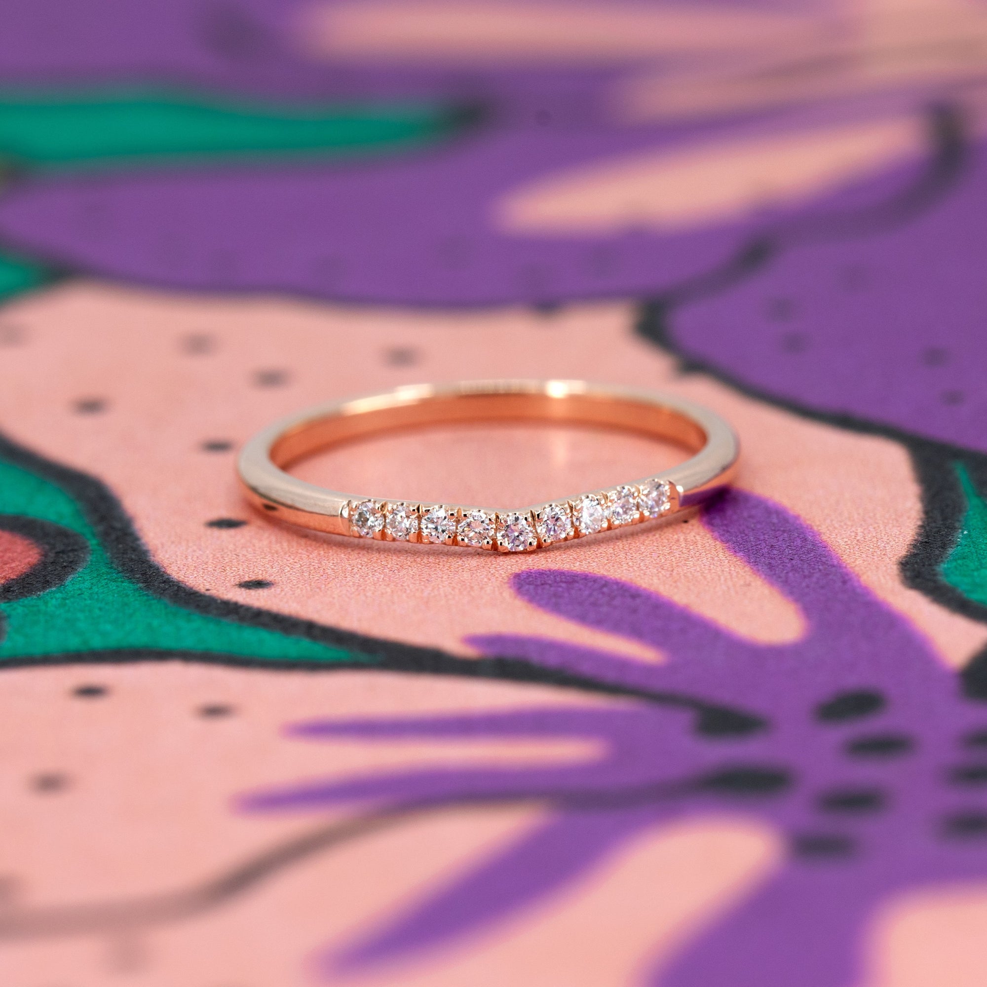 The Luna Band in rose gold, photographed on a contrasting background to highlight its warm glow and sparkling diamonds. Designed in Montreal by Bena Jewelry.